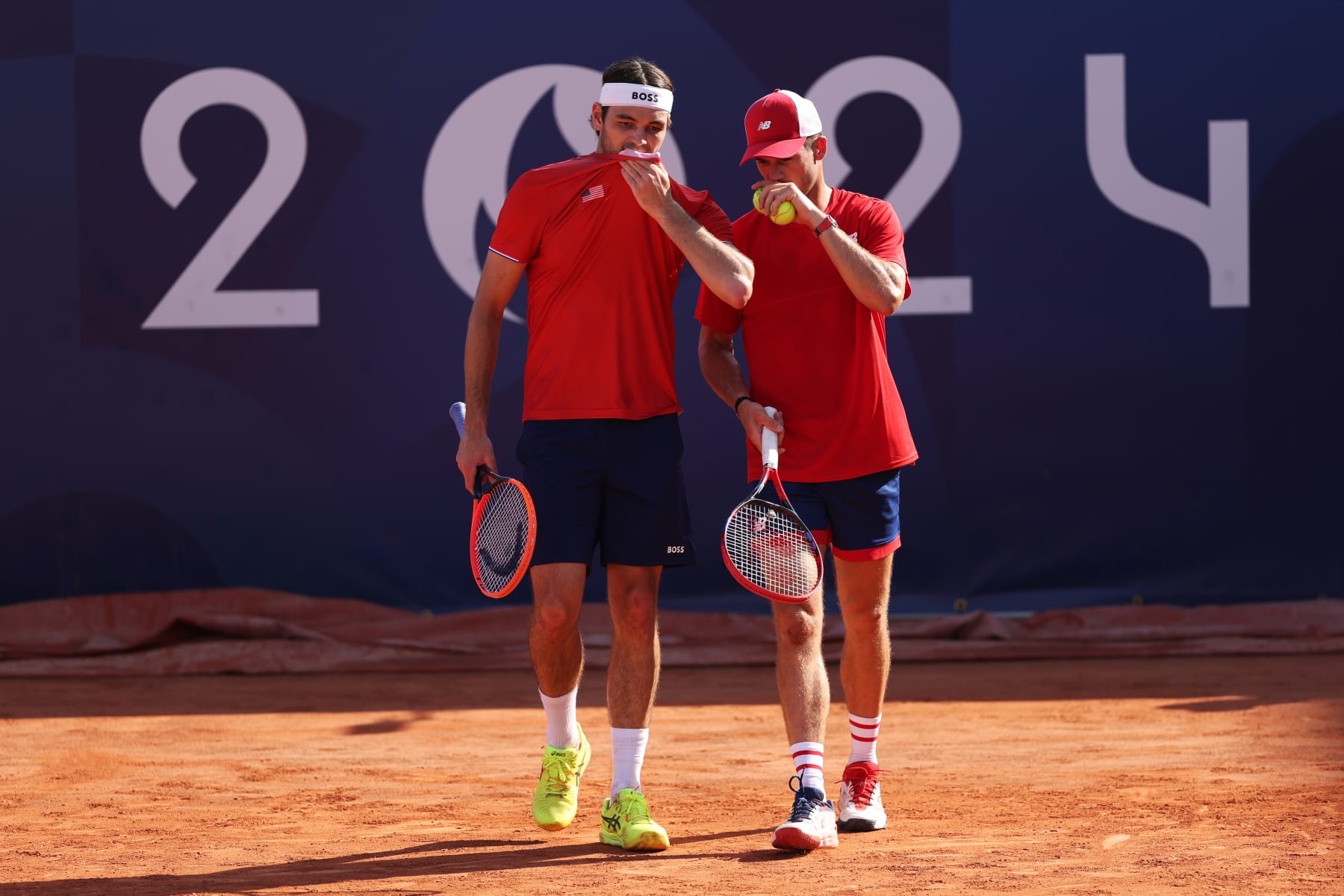 PARIS, FRANCE - JULY 29: Tommy Paul (R) and partner Taylor Fritz of Team United States interact against Milos Raonic and Felix Auger-Aliassime of Team Canada during the Men's Doubles first round match on day three of the Olympic Games Paris 2024 at Roland Garros on July 29, 2024 in Paris, France. (Photo by Matthew Stockman/Getty Images)