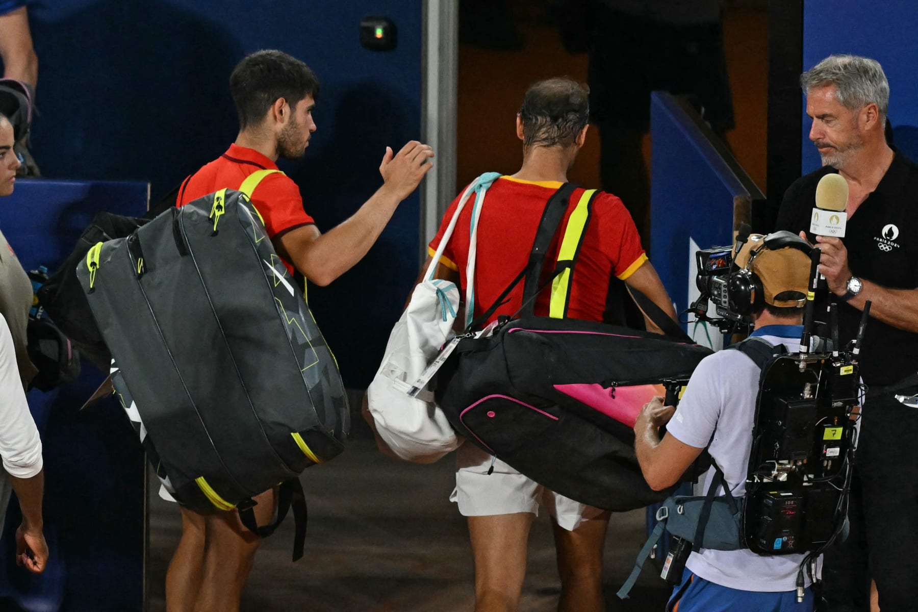 Spain's Rafael Nadal (C) leaves the court with Spain's Carlos Alcaraz (L) after they lose to US' Austin Krajicek and US' Rajeev Ram in their men's doubles quarter-final tennis match on Court Philippe-Chatrier at the Roland-Garros Stadium during the Paris 2024 Olympic Games, in Paris on July 31, 2024. (Photo by PATRICIA DE MELO MOREIRA / AFP) (Photo by PATRICIA DE MELO MOREIRA/AFP via Getty Images)