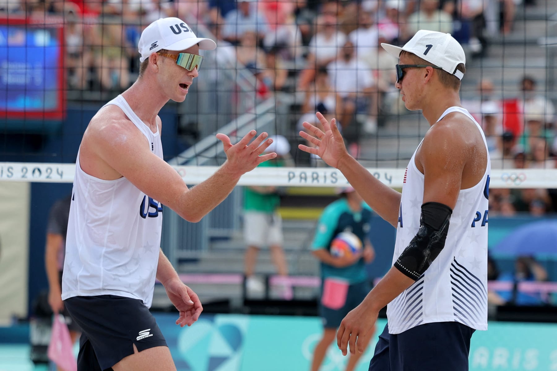 US' #01 Miles Partain (L) and US' #02 Andrew Benesh celebrate a point in the men's pool D beach volleyball match between Brazil and USA during the Paris 2024 Olympic Games at the Eiffel Tower Stadium in Paris on August 1, 2024. (Photo by Thomas SAMSON / AFP) (Photo by THOMAS SAMSON/AFP via Getty Images)
