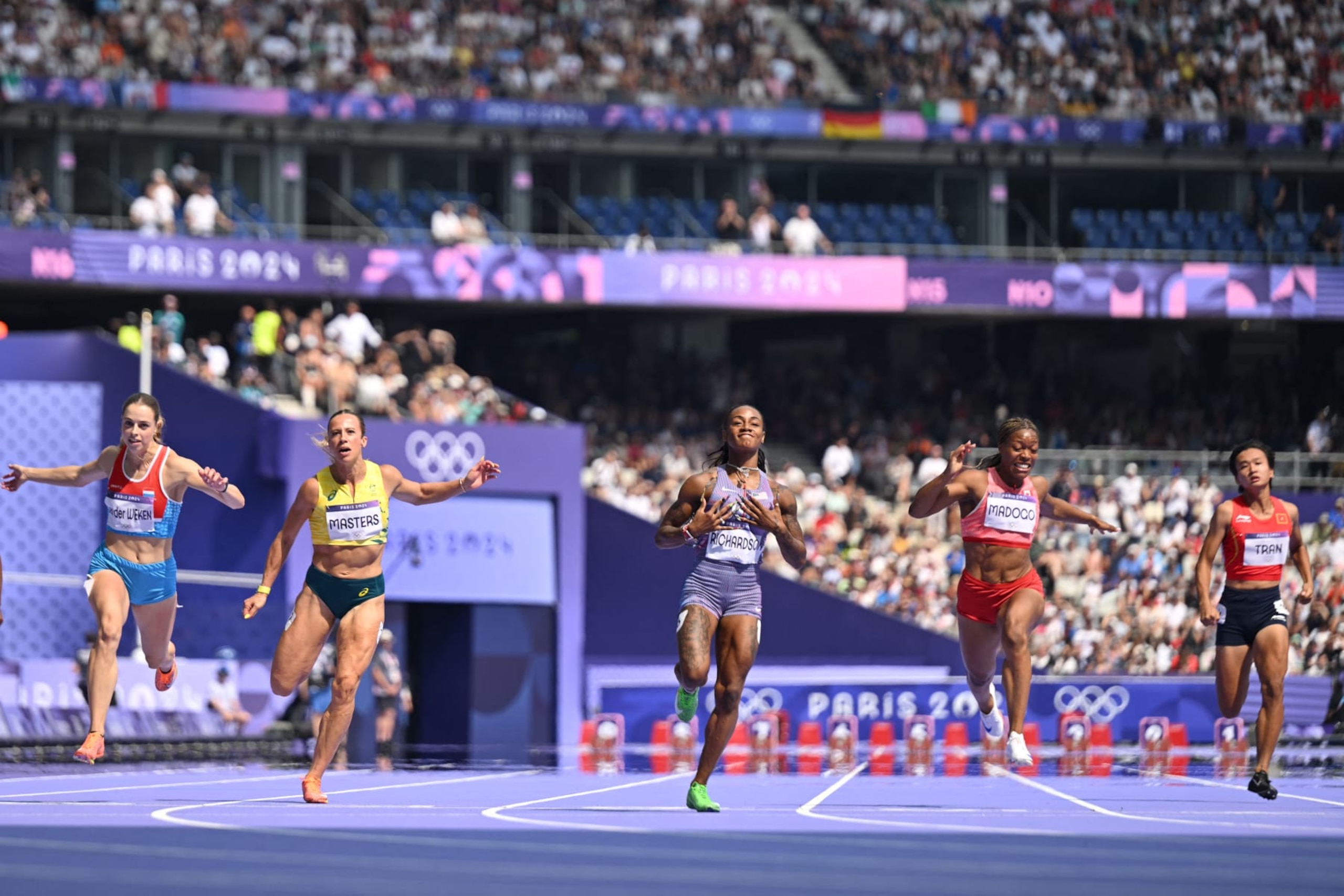 TOPSHOT - US' Sha'Carri Richardson (C) celebrates after winning the women's 100m heat of the athletics event at the Paris 2024 Olympic Games at Stade de France in Saint-Denis, north of Paris, on August 2, 2024. (Photo by Jewel SAMAD / AFP) (Photo by JEWEL SAMAD/AFP via Getty Images)