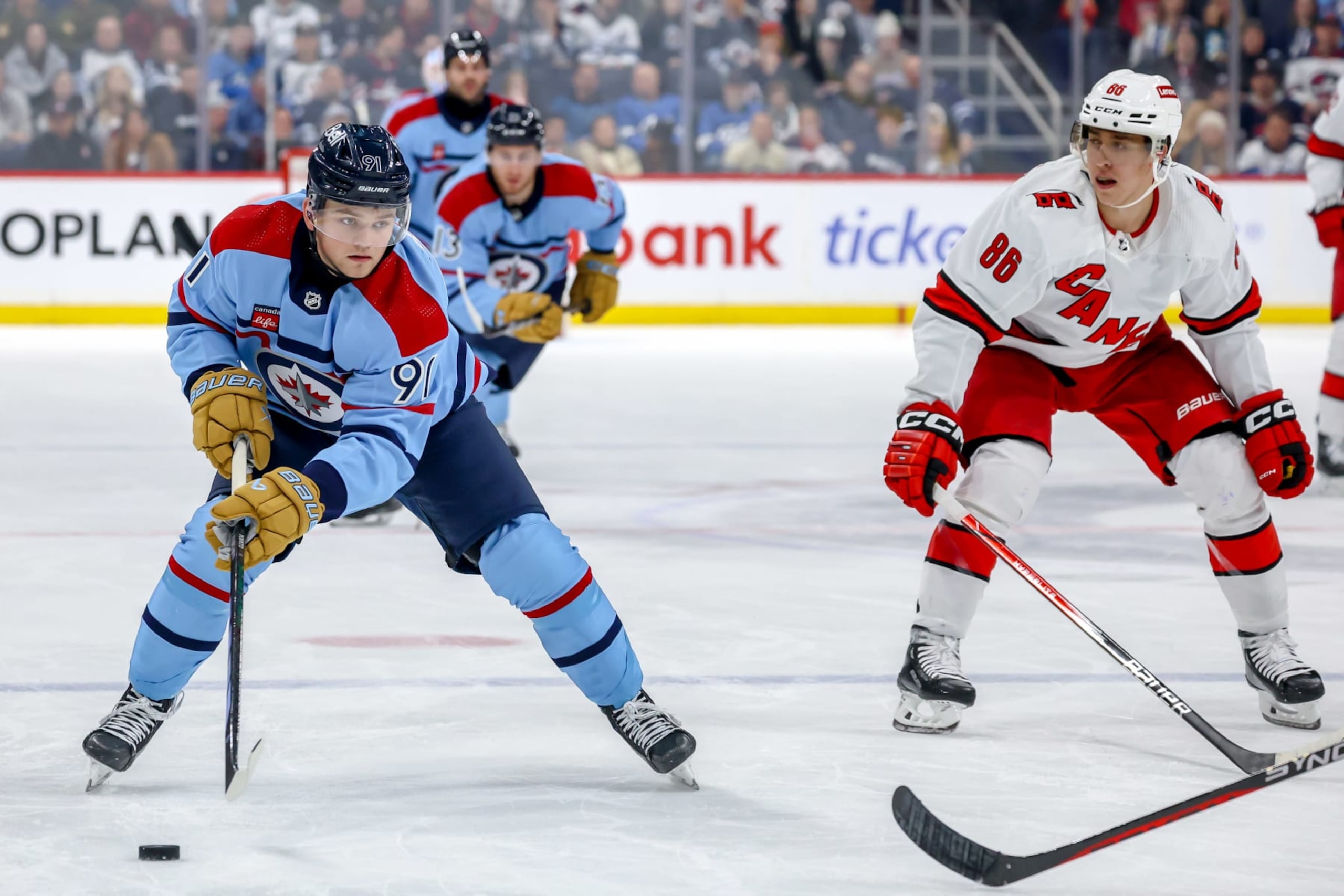 Winnipeg Jets forward Cole Perfetti (left) and Carolina Hurricanes winger Martin NeÄas. 