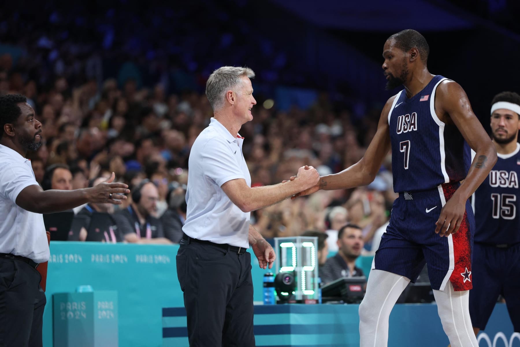 USA's #07 Kevin Durant taps hand with USA's coach Steve Kerr in the men's preliminary round group C basketball match between Serbia and USA during the Paris 2024 Olympic Games at the Pierre-Mauroy stadium in Villeneuve-d'Ascq, northern France, on July 28, 2024. (Photo by Thomas COEX / AFP) (Photo by THOMAS COEX/AFP via Getty Images)
