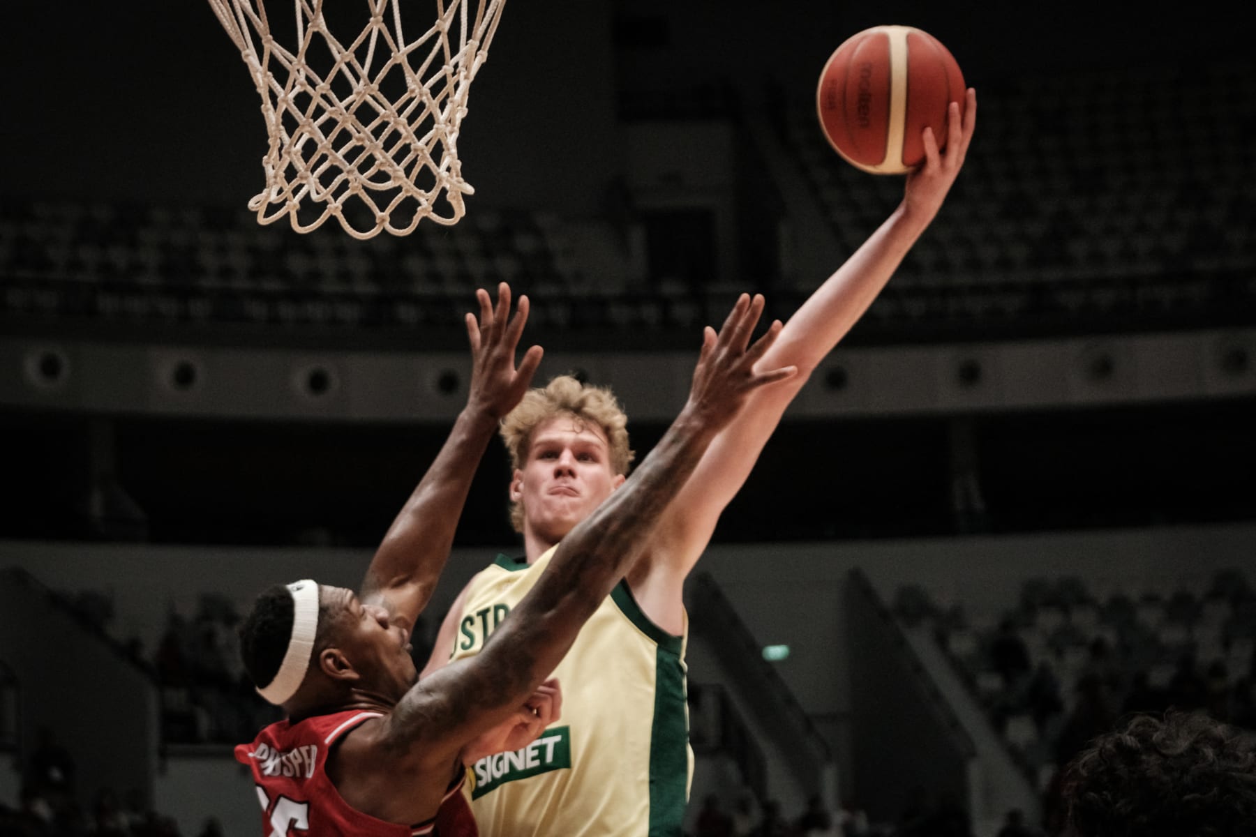 Australia's Rocco Zikarsky (R) shoots against Indonesia's Lester Prosper during the FIBA Basketball Asia Cup qualifier match between Indonesia and Australia at Indonesia Arena in Jakarta on February 25, 2024. (Photo by YASUYOSHI CHIBA / AFP) (Photo by YASUYOSHI CHIBA/AFP via Getty Images)