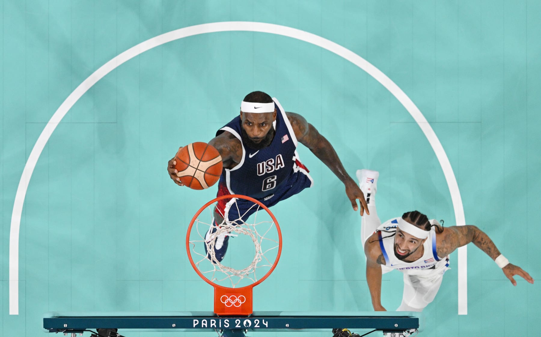 LILLE, FRANCE - AUGUST 03: (EDITORS NOTE: Image was captured using a remote camera positioned above the field of play) Lebron James #6 of Team United States goes up for a basket past Jose Alvarado #10 of Team Puerto Rico during a Men's basketball group phase-group C game between the United States and Puerto Rico on day eight of the Olympic Games Paris 2024 at Stade Pierre Mauroy on August 03, 2024 in Lille, France. (Photo by Pool/Getty Images)