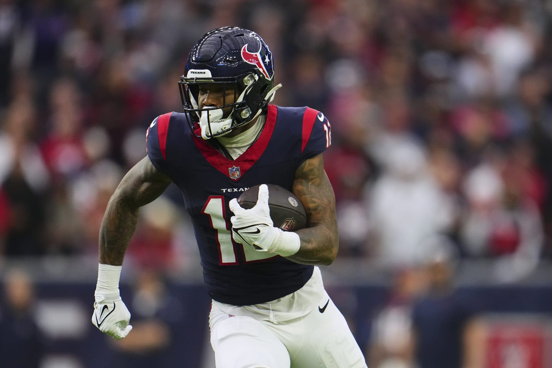 HOUSTON, TX - JANUARY 13: Nico Collins #12 of the Houston Texans runs with the ball against the Cleveland Browns during the first half of the AFC Wild Card playoff game at NRG Stadium on January 13, 2024 in Houston, Texas. (Photo by Cooper Neill/Getty Images)
