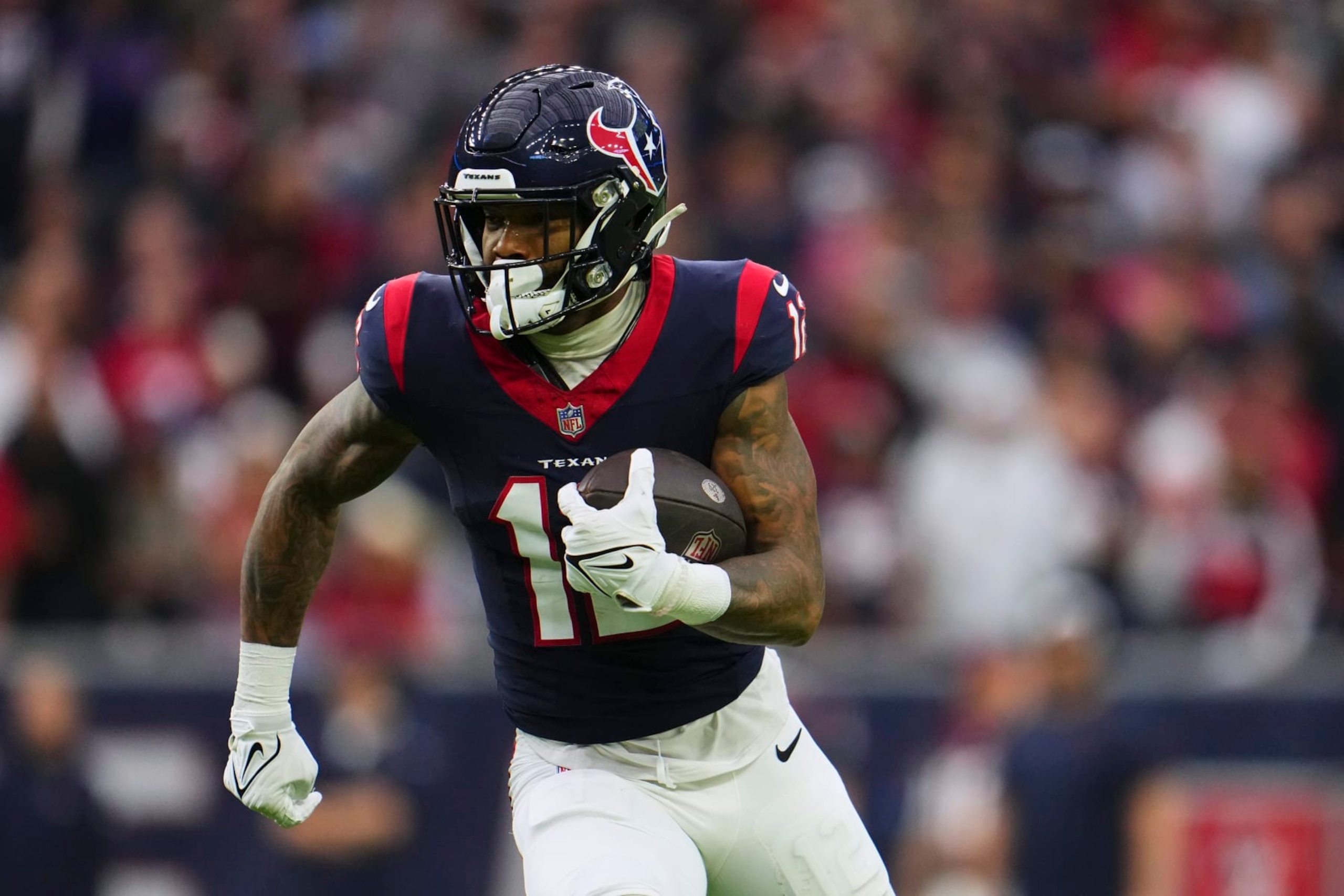 HOUSTON, TX - JANUARY 13: Nico Collins #12 of the Houston Texans runs with the ball against the Cleveland Browns during the first half of the AFC Wild Card playoff game at NRG Stadium on January 13, 2024 in Houston, Texas. (Photo by Cooper Neill/Getty Images)