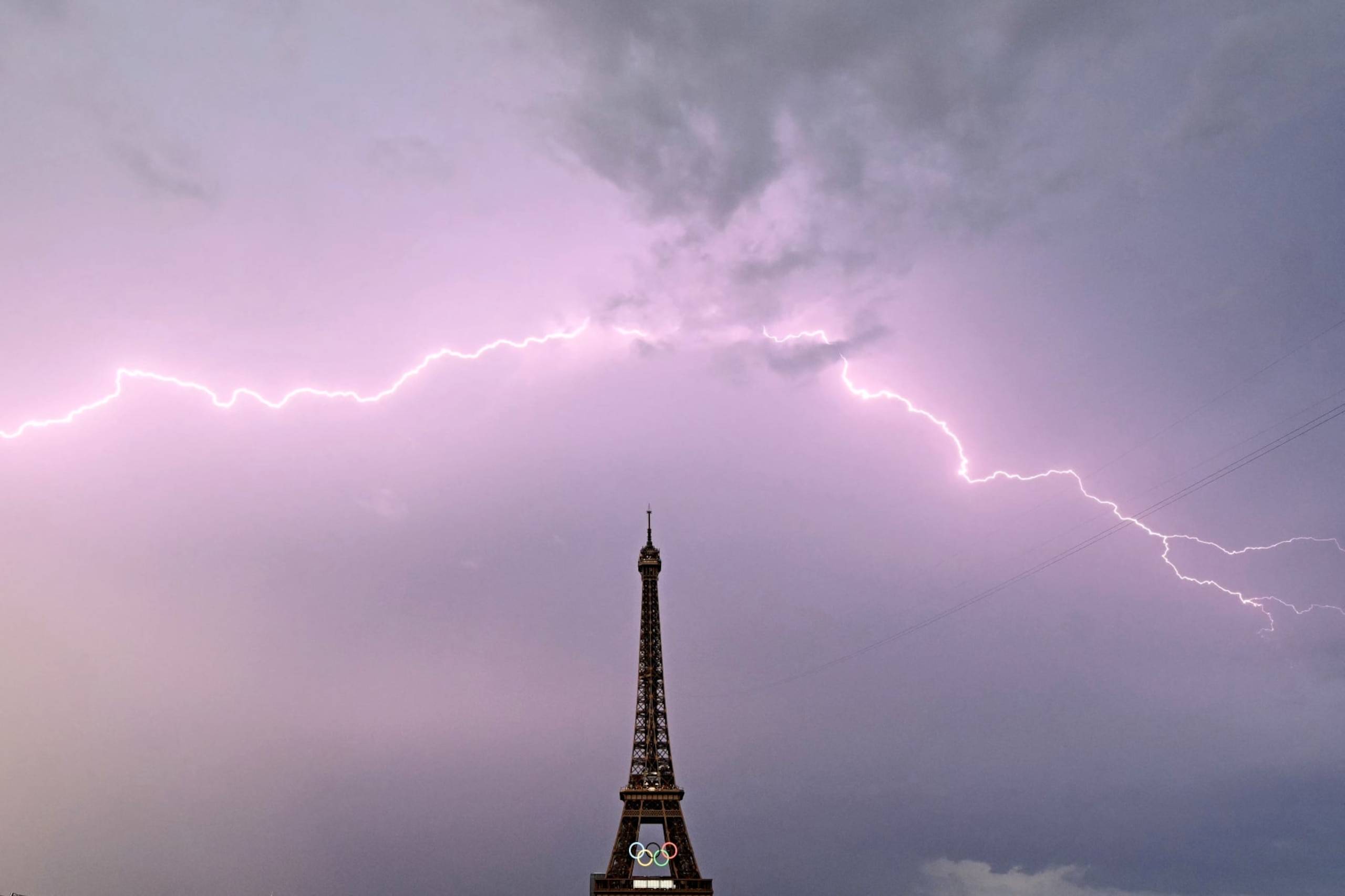 TOPSHOT - A lightning strikes is seen close to the Eiffel tower prior the men's 20km race walk of the athletics event at the Paris 2024 Olympic Games at Trocadero in Paris on August 1, 2024. (Photo by Loic VENANCE / AFP) (Photo by LOIC VENANCE/AFP via Getty Images)