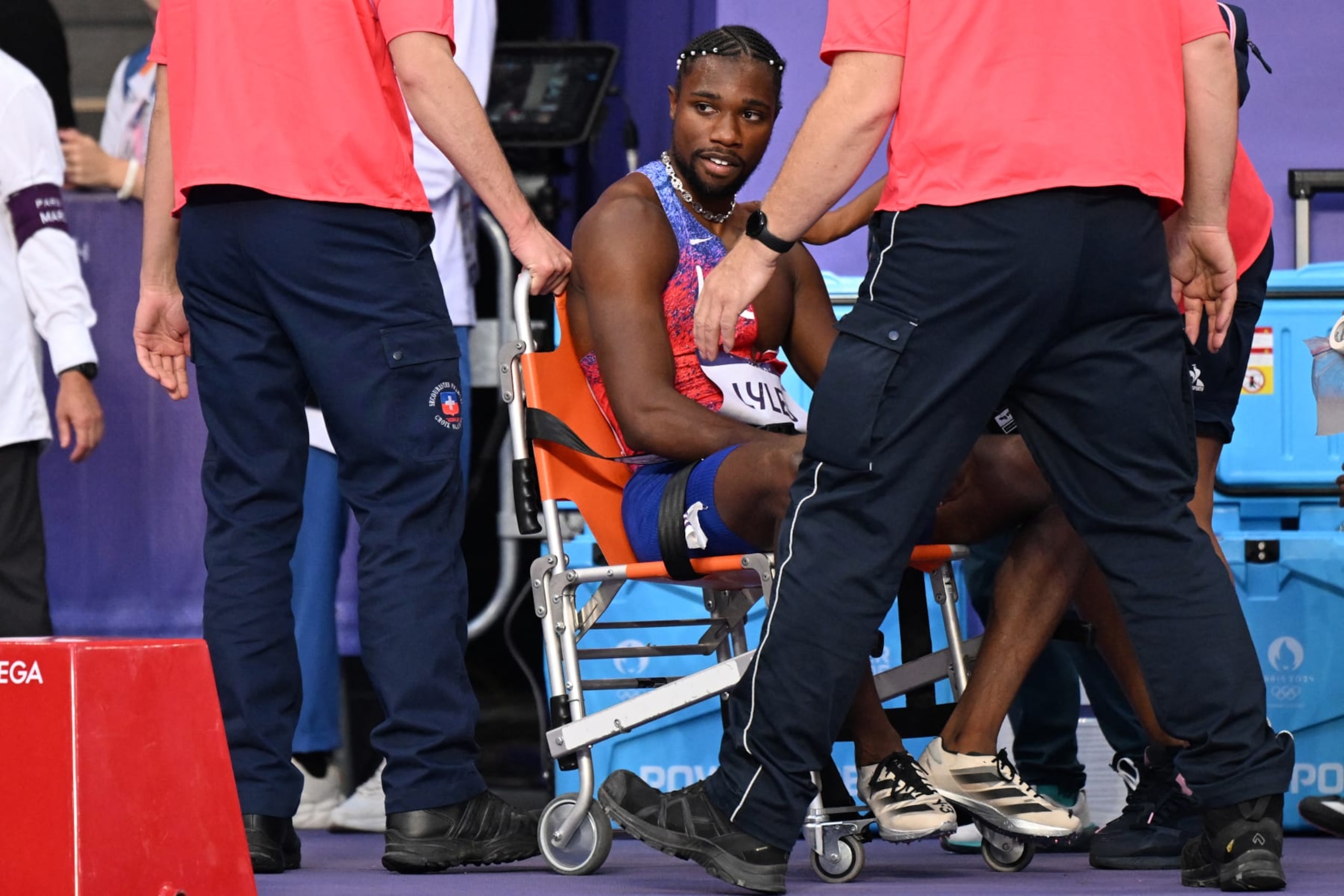 TOPSHOT - Bronze medallist US' Noah Lyles (C) receives medical attention after competing in the men's 200m final of the athletics event at the Paris 2024 Olympic Games at Stade de France in Saint-Denis, north of Paris, on August 8, 2024. (Photo by Kirill KUDRYAVTSEV / AFP) (Photo by KIRILL KUDRYAVTSEV/AFP via Getty Images)