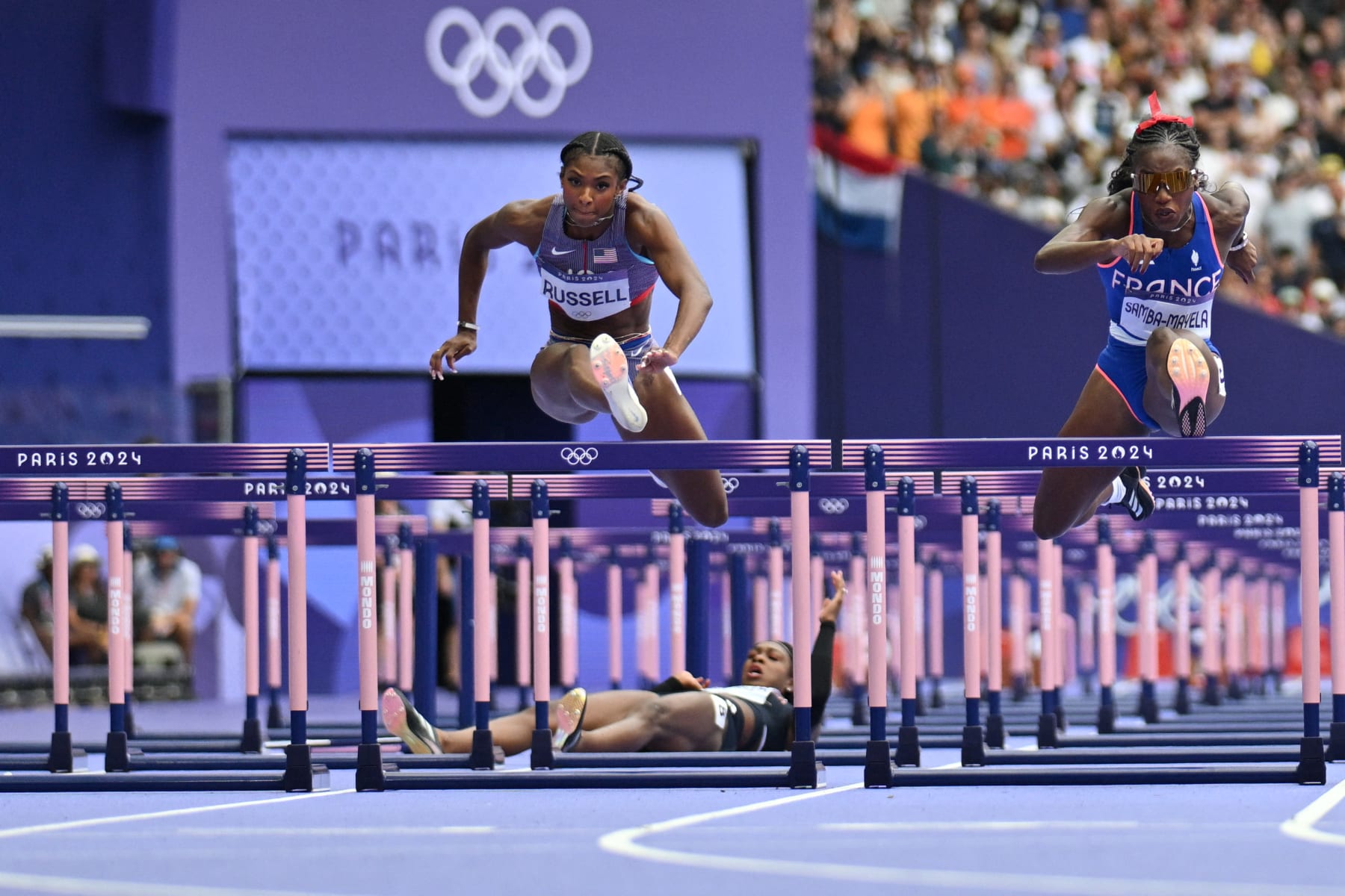 US' Masai Russell and France's Cyrena Samba-Mayela compete in the women's 100m hurdles semi-final of the athletics event at the Paris 2024 Olympic Games at Stade de France in Saint-Denis, north of Paris, on August 9, 2024. (Photo by Jewel SAMAD / AFP) (Photo by JEWEL SAMAD/AFP via Getty Images)