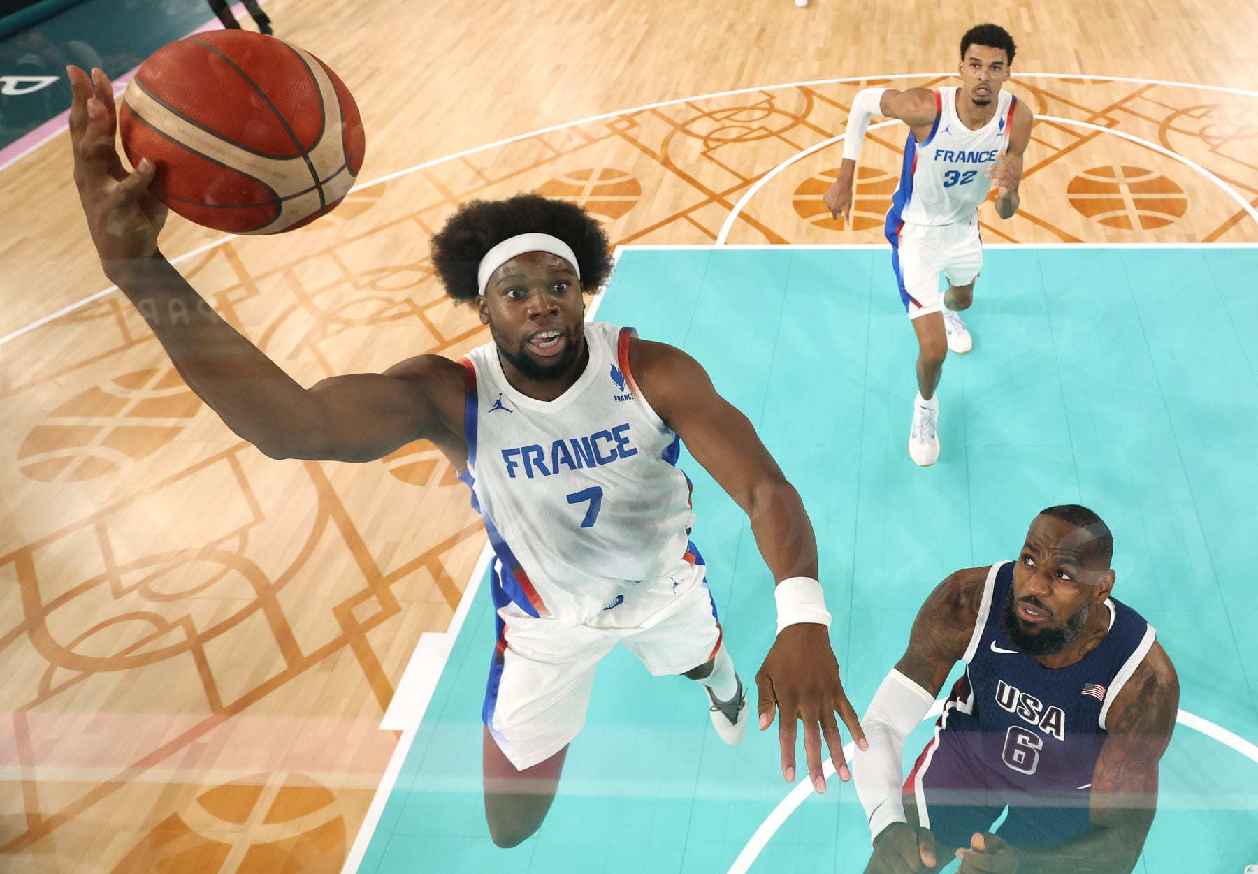 PARIS, FRANCE - AUGUST 10: (EDITORS NOTE: Image was captured using a remote camera positioned above the field of play) Guerschon Yabusele #7 of Team France goes up for a basket past Lebron James #6 of Team United States during the Men's Gold Medal game between Team France and Team United States on day fifteen of the Olympic Games Paris 2024 at Bercy Arena on August 10, 2024 in Paris, France. (Photo by Gregory Shamus/Getty Images)