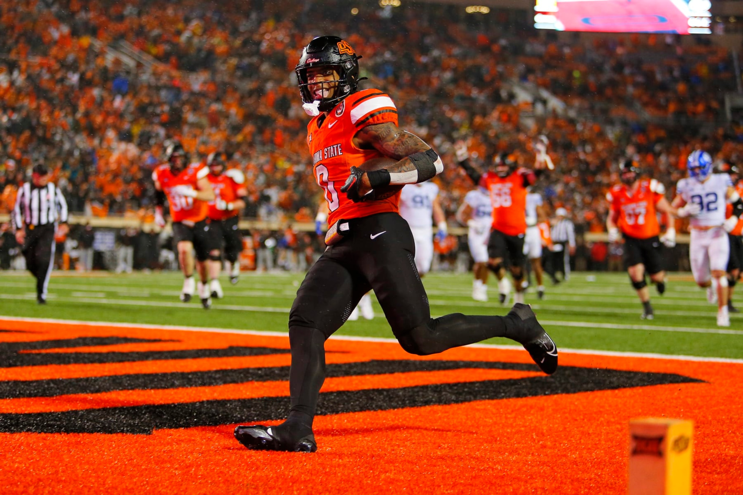 STILLWATER, OK - NOVEMBER 25:  Running back Ollie Gordon II #0 of the Oklahoma State Cowboys sticks out his tongue after scoring a go-ahead touchdown against the BYU Cougars late in the fourth quarter at Boone Pickens Stadium on November 25, 2023 in Stillwater, Oklahoma.  Oklahoma State won 40-34 in double overtime.  (Photo by Brian Bahr/Getty Images)