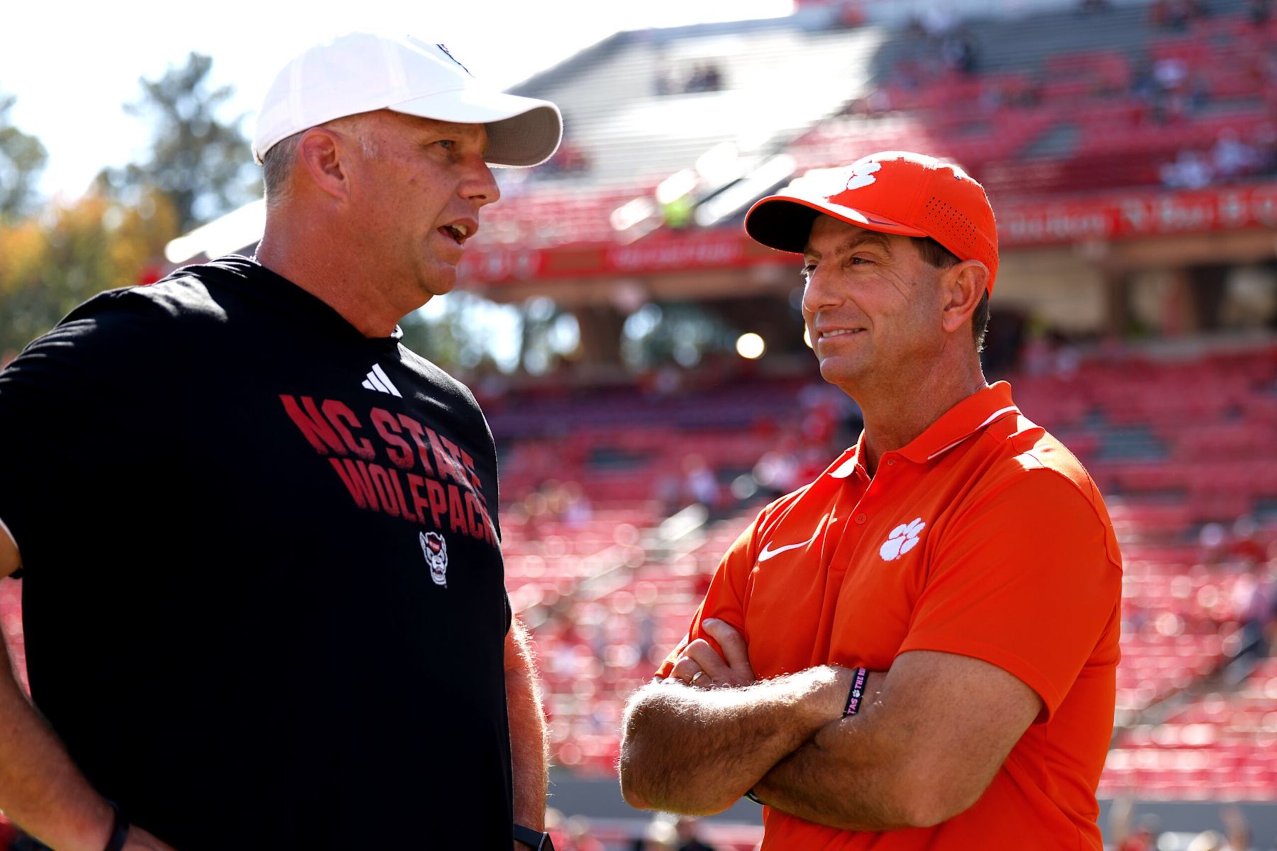 Head coach Dave Doeren of the NC State Wolfpack talks with head coach Dabo Swinney of the Clemson Tigers.