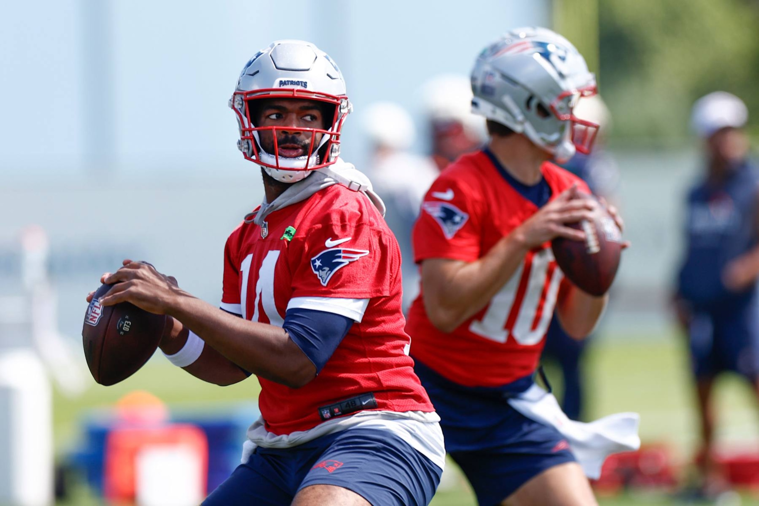 Foxborough, MA - August 12: New England Patriots QBs Jacoby Brissett, left, and Drake Maye throw passes. (Photo by Danielle Parhizkaran/The Boston Globe via Getty Images)