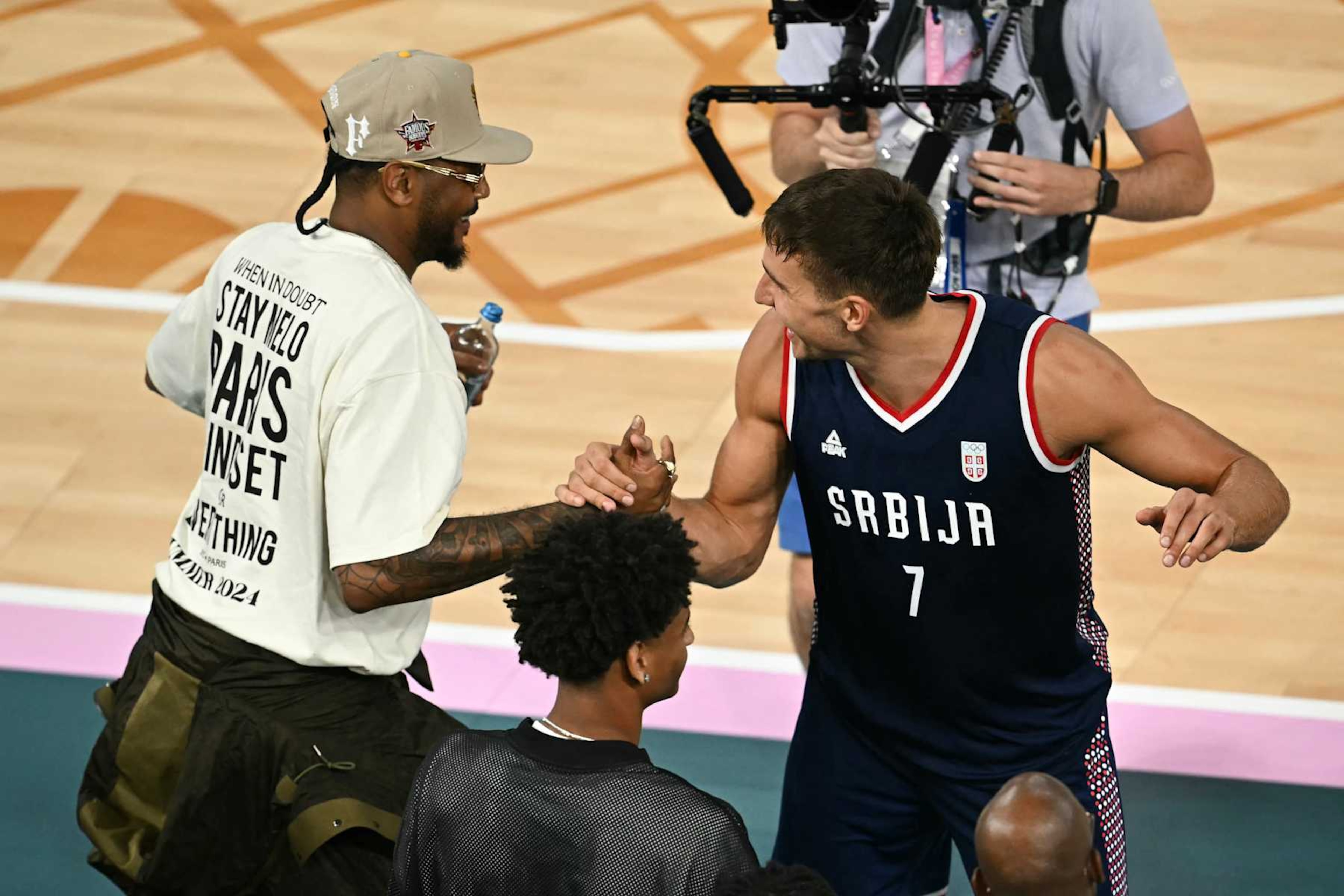 Serbia's #07 Bogdan Bogdanovic shakes hads with US basketball player Carmelo Anthony (L) after the men's Bronze Medal basketball match between Germany and Serbia during the Paris 2024 Olympic Games at the Bercy Arena in Paris on August 10, 2024. (Photo by Paul ELLIS / AFP) (Photo by PAUL ELLIS/AFP via Getty Images) Serbia's #07 Bogdan Bogdanovic shakes hads with US basketball player Carmelo Anthony (L) after the men's Bronze Medal basketball match between Germany and Serbia during the Paris 2024 Olympic Games at the Bercy Arena in Paris on August 10, 2024. (Photo by Paul ELLIS / AFP) (Photo by PAUL ELLIS/AFP via Getty Images)