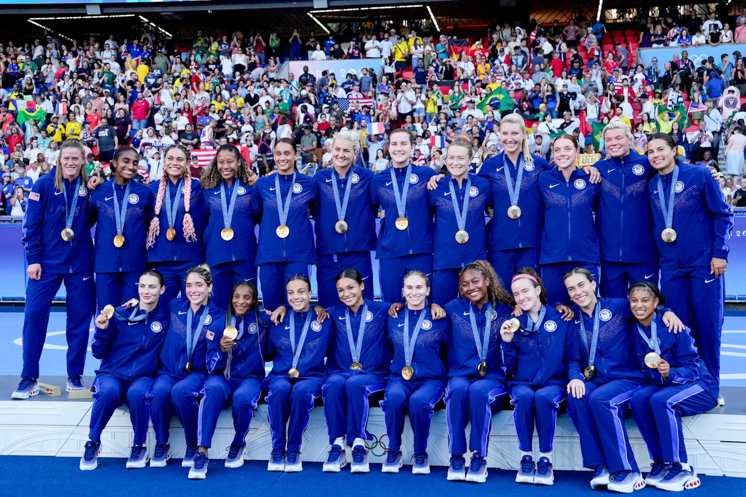 PARIS, FRANCE - AUGUST 10:  (L-R) Alyssa Naeher , Naomi Girma , Emily Fox , Trinity Rodman , Korbin Albert , Crystal Dunn , Casey Krueger , Lynn Williams , Mallory Swanson , Sophia Smith , Lindsey Horan , Tierna Davidson , Jenna Nighswonger , Emily Sonnett , Jaedyn Shaw , Casey Murphy , Rose Lavelle , Samantha Coffey of United States celebrating their victory and posing with their gold medals during the Women's Gold Medal match between Brazil and United States of America during the Olympic Games Paris 2024 at Parc des Princes on August 10, 2024 in Paris, France. (Photo by Daniela Porcelli/ISI Photos/Getty Images)