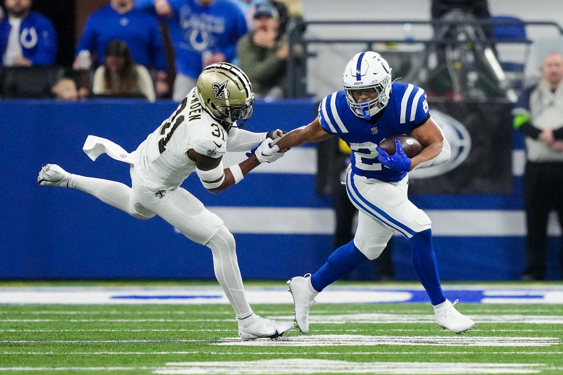 INDIANAPOLIS, INDIANA - OCTOBER 29: Jonathan Taylor #28 of the Indianapolis Colts runs with the ball while being chased by Jordan Howden #31 of the New Orleans Saints in the first quarter at Lucas Oil Stadium on October 29, 2023 in Indianapolis, Indiana. (Photo by Dylan Buell/Getty Images)