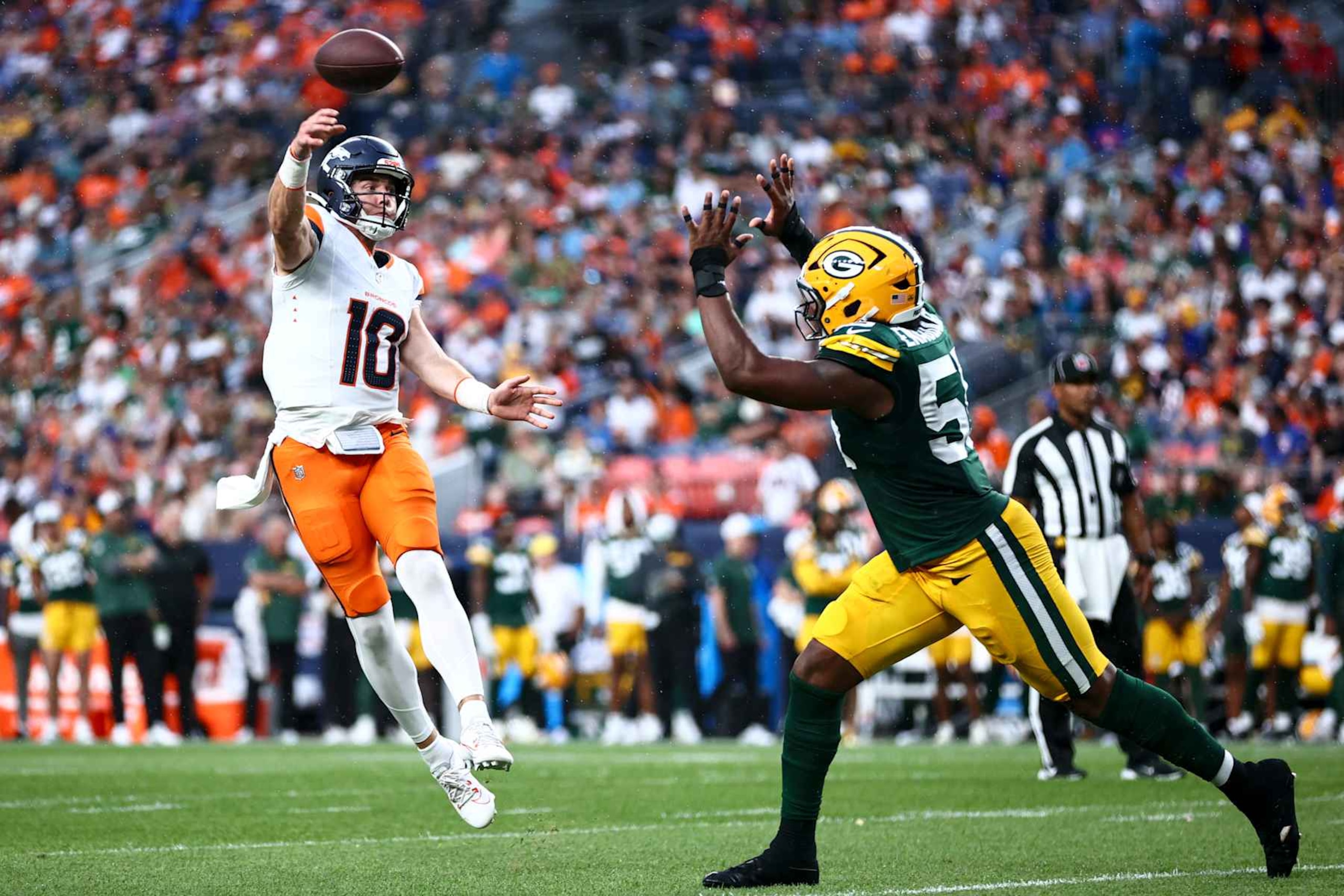 DENVER, COLORADO - AUGUST 18: Bo Nix #10 of the Denver Broncos throws a touchdown pass to Tim Patrick #12 in the second quarter during the preseason game against the Green Bay Packers at Empower Field At Mile High on August 18, 2024 in Denver, Colorado. (Photo by Tyler Schank/Getty Images)