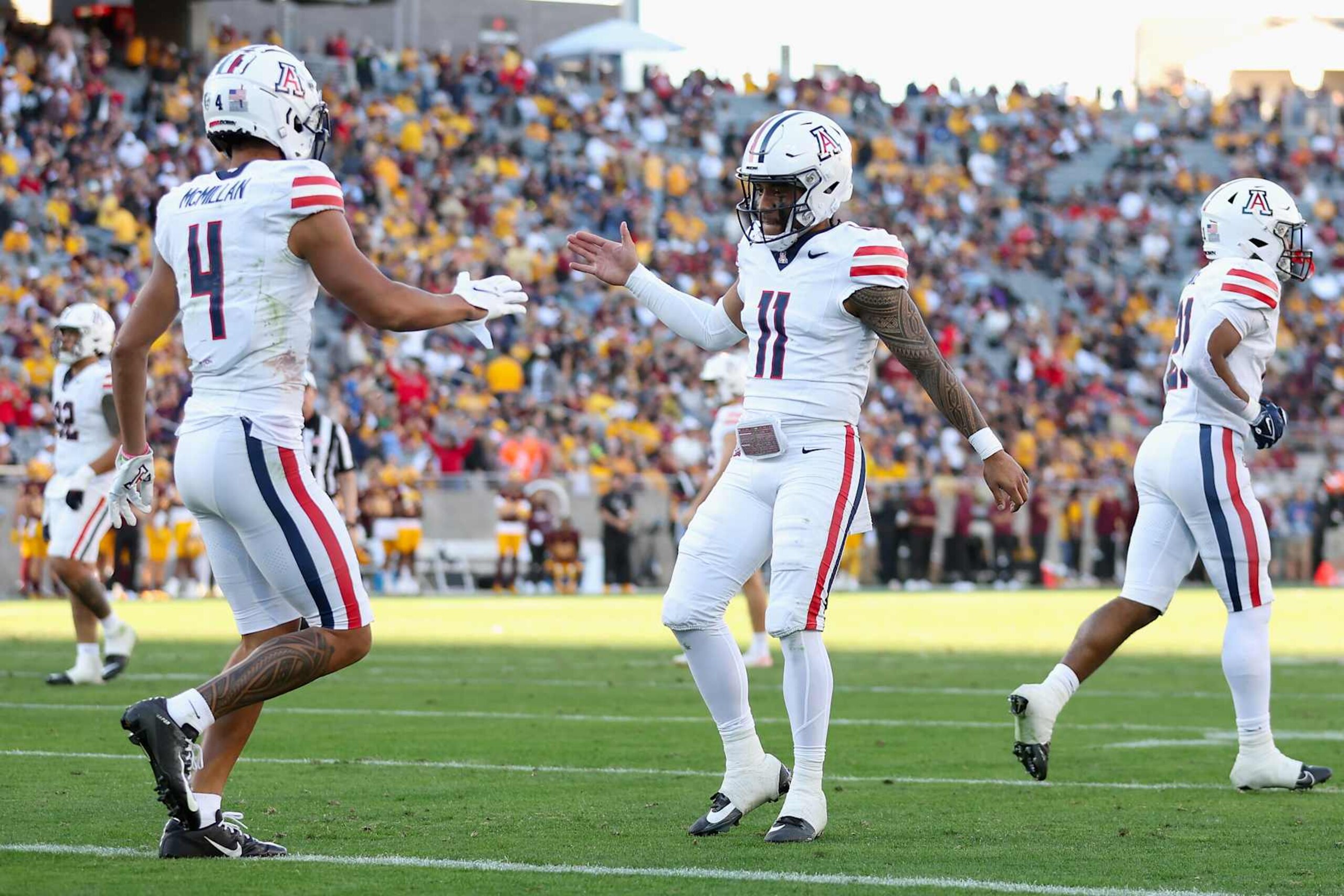 TEMPE, ARIZONA - NOVEMBER 25: Wide receiver Tetairoa McMillan #4 of the Arizona Wildcats celebrates with Noah Fifita #11 after catching a 50-yard touchdown reception against the Arizona State Sun Devils during the second half of the NCAAF game at Mountain America Stadium on November 25, 2023 in Tempe, Arizona. (Photo by Christian Petersen/Getty Images) TEMPE, ARIZONA - NOVEMBER 25: Wide receiver Tetairoa McMillan #4 of the Arizona Wildcats celebrates with Noah Fifita #11 after catching a 50-yard touchdown reception against the Arizona State Sun Devils during the second half of the NCAAF game at Mountain America Stadium on November 25, 2023 in Tempe, Arizona. (Photo by Christian Petersen/Getty Images)