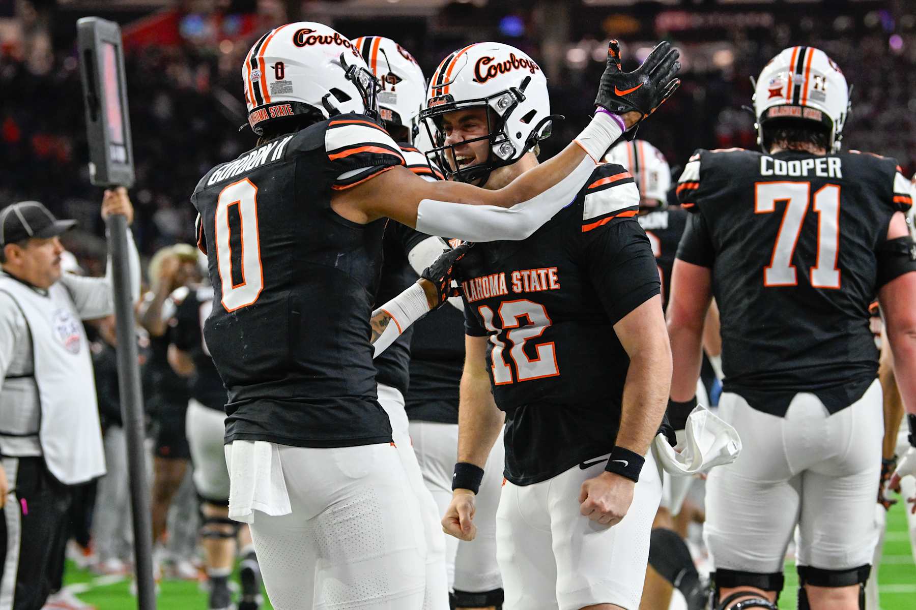 HOUSTON, TX - DECEMBER 27: Oklahoma State Cowboys quarterback Gunnar Gundy (12) is congratulated by Oklahoma State Cowboys running back Ollie Gordon II (0) after scoring a first half rushing touchdown during the TaxAct Texas Bowl between the Texas A&M Aggies and Oklahoma State Cowboys at NRG Stadium on December 27, 2023 in Houston, Texas. (Photo by Ken Murray/Icon Sportswire via Getty Images)
