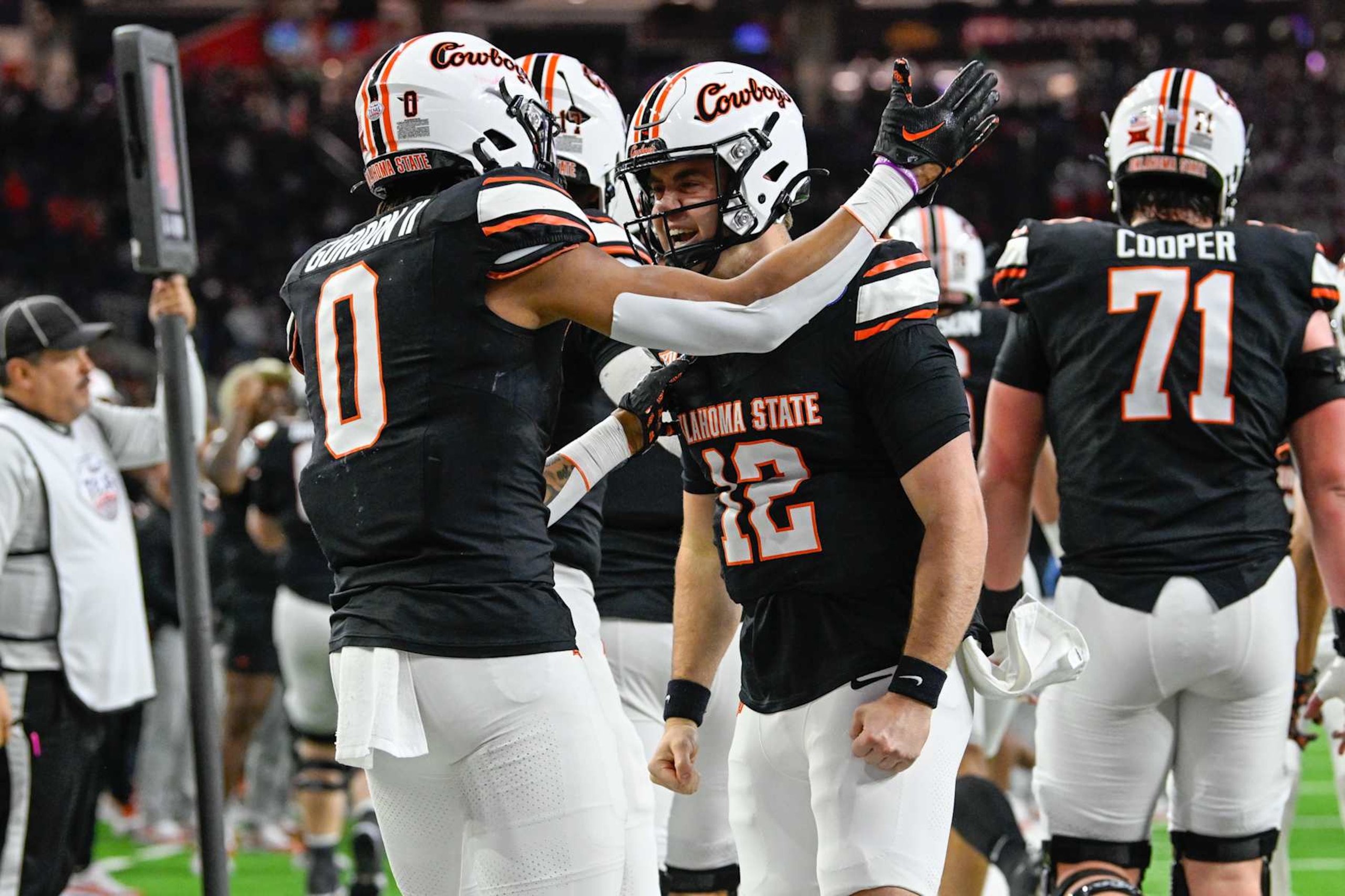 HOUSTON, TX - DECEMBER 27: Oklahoma State Cowboys quarterback Gunnar Gundy (12) is congratulated by Oklahoma State Cowboys running back Ollie Gordon II (0) after scoring a first half rushing touchdown during the TaxAct Texas Bowl between the Texas A&M Aggies and Oklahoma State Cowboys at NRG Stadium on December 27, 2023 in Houston, Texas. (Photo by Ken Murray/Icon Sportswire via Getty Images) HOUSTON, TX - DECEMBER 27: Oklahoma State Cowboys quarterback Gunnar Gundy (12) is congratulated by Oklahoma State Cowboys running back Ollie Gordon II (0) after scoring a first half rushing touchdown during the TaxAct Texas Bowl between the Texas A&M Aggies and Oklahoma State Cowboys at NRG Stadium on December 27, 2023 in Houston, Texas. (Photo by Ken Murray/Icon Sportswire via Getty Images)
