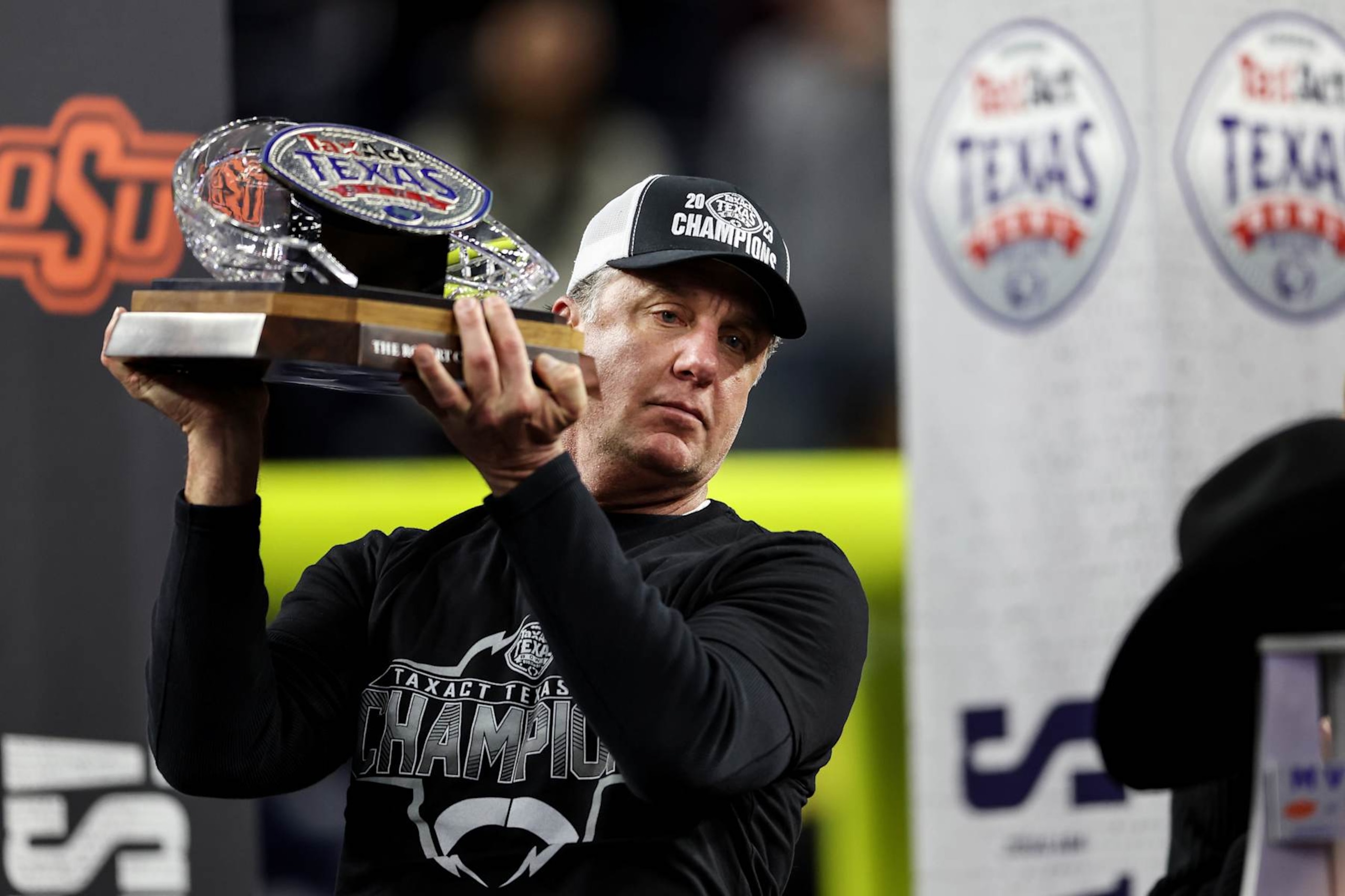 HOUSTON, TEXAS - DECEMBER 27: Head coach Mike Gundy of the Oklahoma State Cowboys holds the bowl trophy after defeating the Texas A&M Aggies during the TaxAct Texas Bowl at NRG Stadium on December 27, 2023 in Houston, Texas. (Photo by Tim Warner/Getty Images) HOUSTON, TEXAS - DECEMBER 27: Head coach Mike Gundy of the Oklahoma State Cowboys holds the bowl trophy after defeating the Texas A&M Aggies during the TaxAct Texas Bowl at NRG Stadium on December 27, 2023 in Houston, Texas. (Photo by Tim Warner/Getty Images)