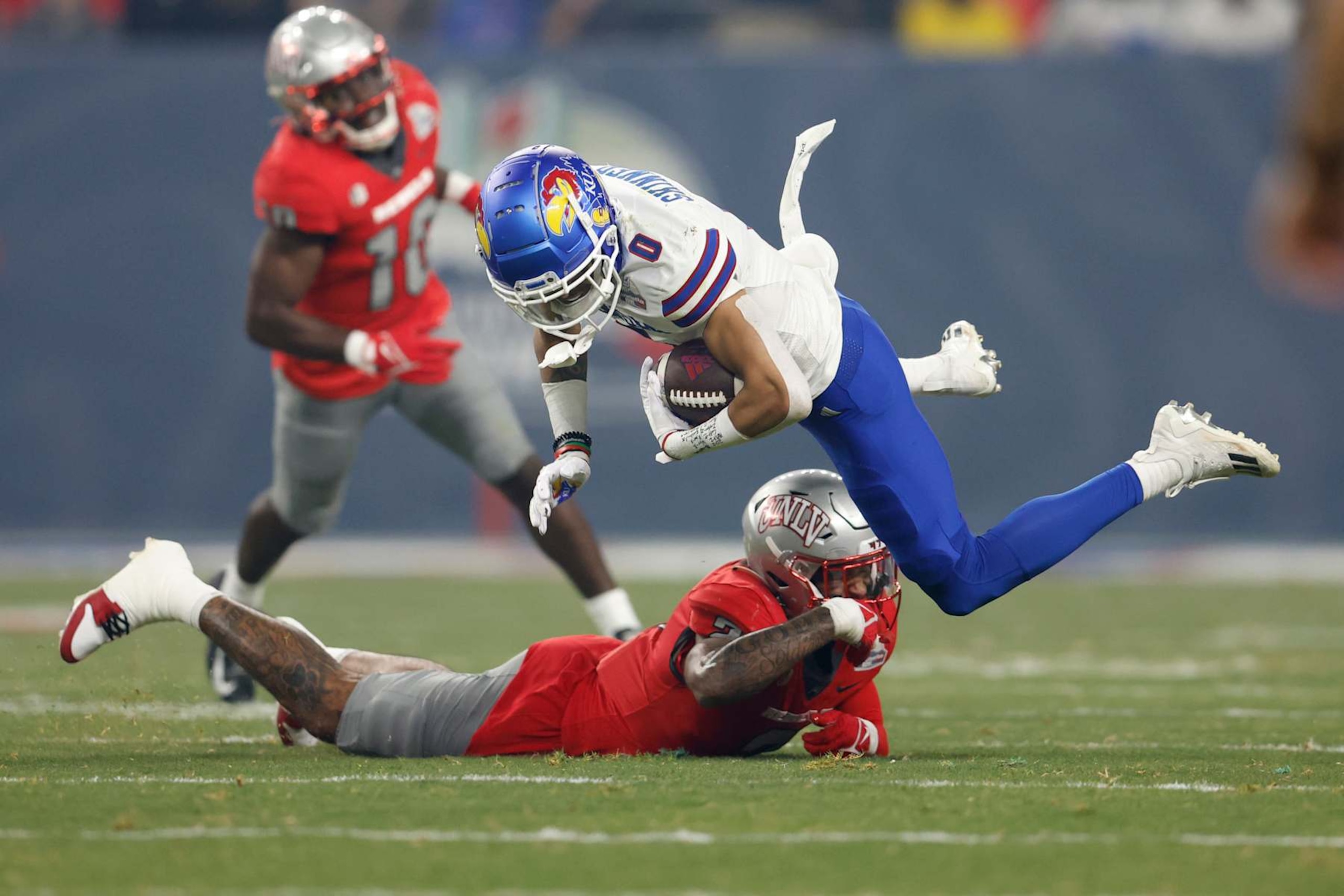 PHOENIX, ARIZONA - DECEMBER 26: Wide receiver Quentin Skinner #0 of the Kansas Jayhawks is tackled by defensive back Jaxen Turner #2 of the UNLV Rebels during the first half of the Guaranteed Rate Bowl at Chase Field on December 26, 2023 in Phoenix, Arizona. (Photo by Chris Coduto/Getty Images) PHOENIX, ARIZONA - DECEMBER 26: Wide receiver Quentin Skinner #0 of the Kansas Jayhawks is tackled by defensive back Jaxen Turner #2 of the UNLV Rebels during the first half of the Guaranteed Rate Bowl at Chase Field on December 26, 2023 in Phoenix, Arizona. (Photo by Chris Coduto/Getty Images)