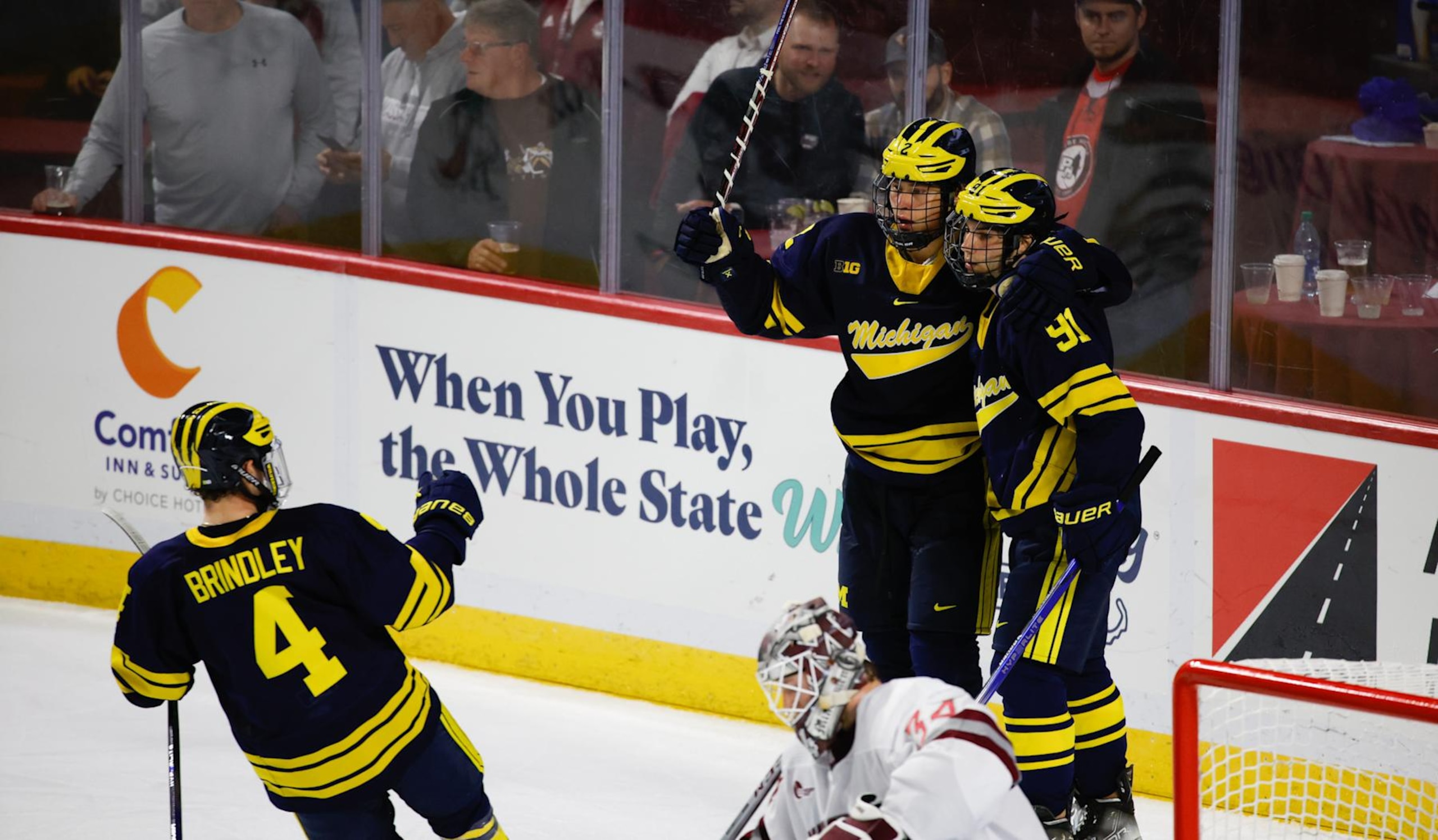 AMHERST, MASSACHUSETTS - OCTOBER 13: Rutger McGroarty #2 of the Michigan Wolverines celebrates his goal against the Massachusetts Minutemen with teammate Frank Nazar III #91 and Gavin Brindley #4 during NCAA men's hockey at the Mullins Center on October 13, 2023 in Amherst, Massachusetts. The Wolverines won 7-2. (Photo by Richard T Gagnon/Getty Images)