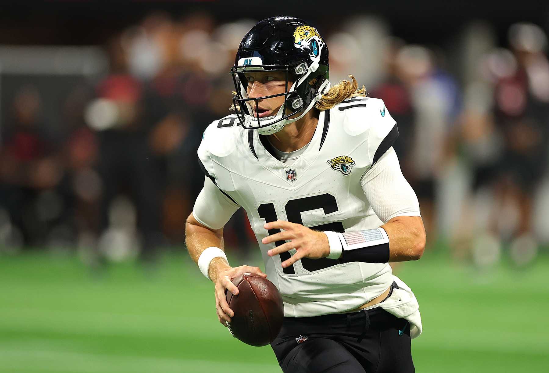 ATLANTA, GEORGIA - AUGUST 23:  Trevor Lawrence #16 of the Jacksonville Jaguars looks to pass the ball as he rolls out of the pocket against the Atlanta Falcons during the first quarter at Mercedes-Benz Stadium on August 23, 2024 in Atlanta, Georgia. (Photo by Kevin C. Cox/Getty Images)