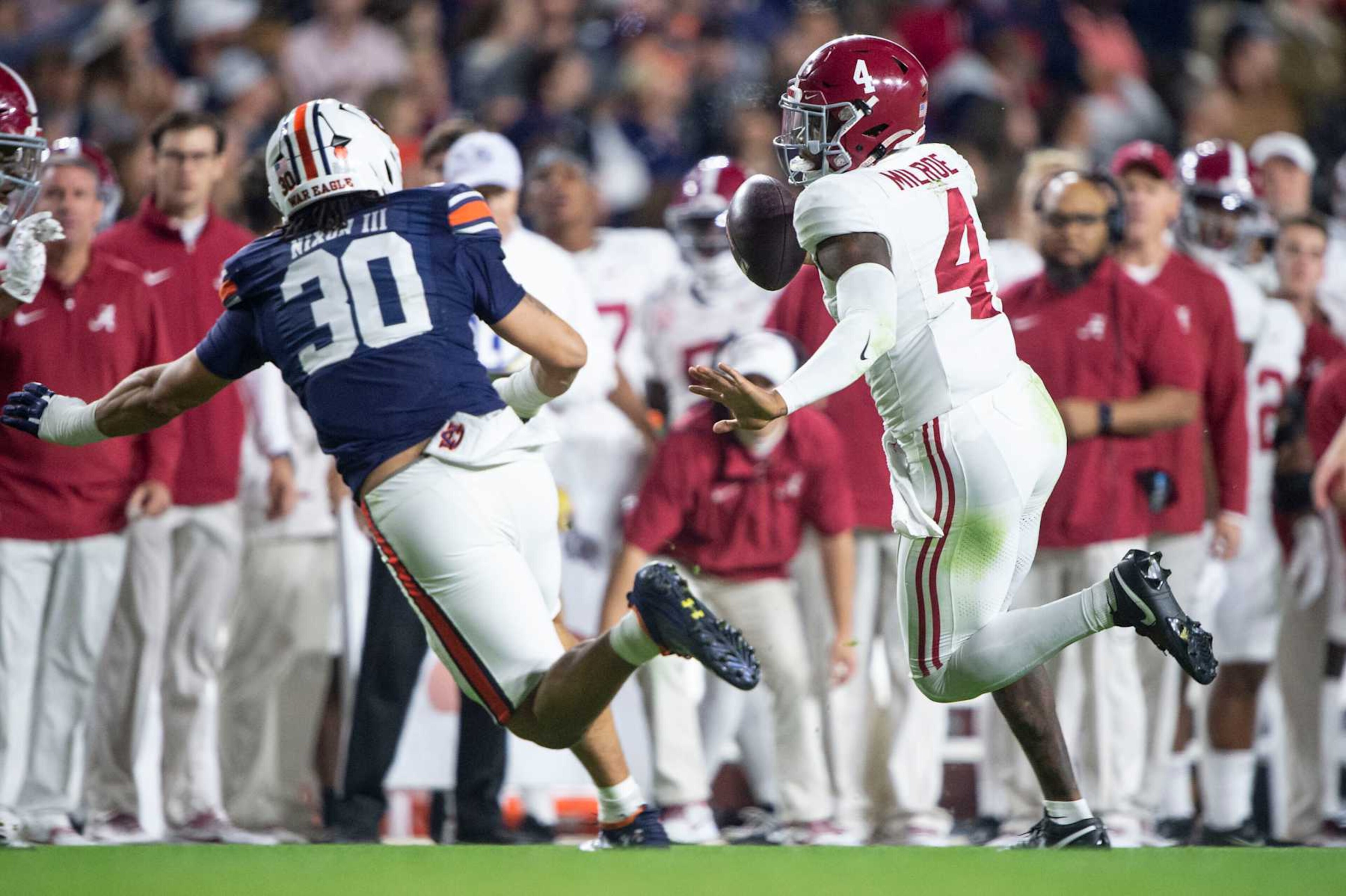 AUBURN, ALABAMA - NOVEMBER 25: Quarterback Jalen Milroe #4 of the Alabama Crimson Tide looks to run the ball by linebacker Larry Nixon III #30 of the Auburn Tigers at Jordan-Hare Stadium on November 25, 2023 in Auburn, Alabama. (Photo by Michael Chang/Getty Images)