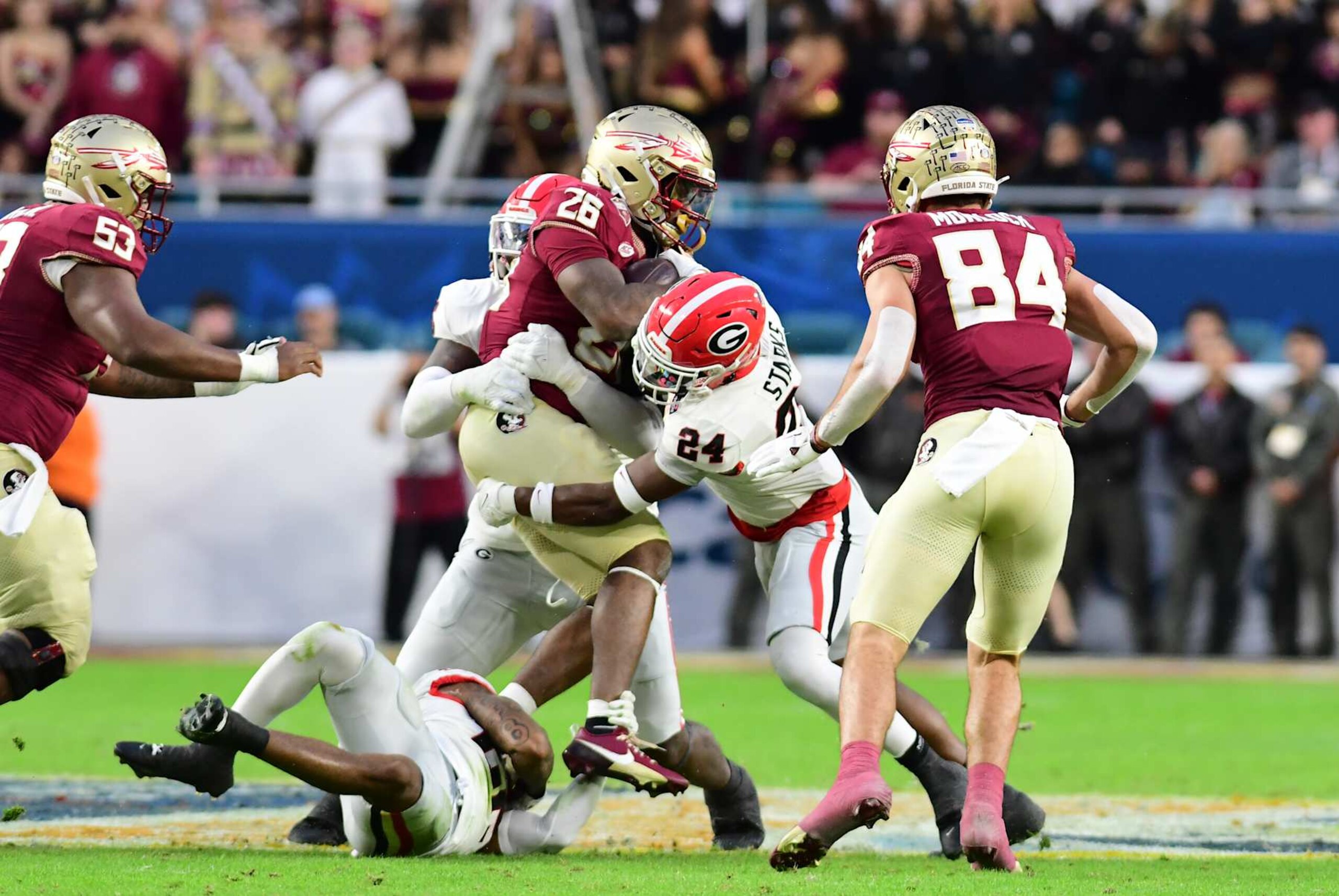 MIAMI GARDENS, FL - DECEMBER 30: Malaki Starks #24 of the Georgia Bulldogs tackles Caziah Holmes #26 of the Florida State Seminoles during the Capital One Orange Bowl game between University of Georgia and Florida State University at Hard Rock Stadium on December 30, 2023 in Miami Gardens, Florida. (Photo by Perry McIntyre/ISI Photos/Getty Images)
