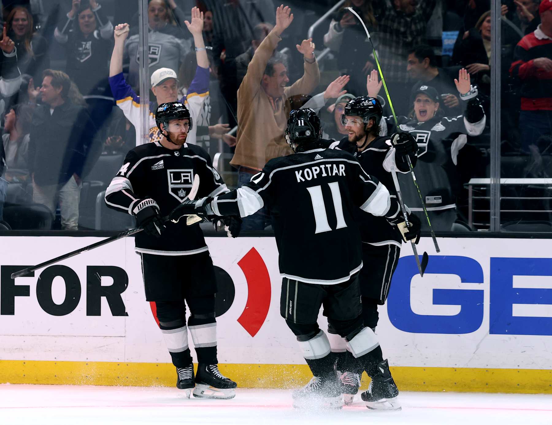 LOS ANGELES, CALIFORNIA - APRIL 18: Adrian Kempe #9 of the Los Angeles Kings celebrates his goal with Vladislav Gavrikov #84 and Anze Kopitar #11 of the Los Angeles Kings for a 5-4 overtime win over the Chicago Blackhawks at Crypto.com Arena on April 18, 2024 in Los Angeles, California. (Photo by Harry How/Getty Images)