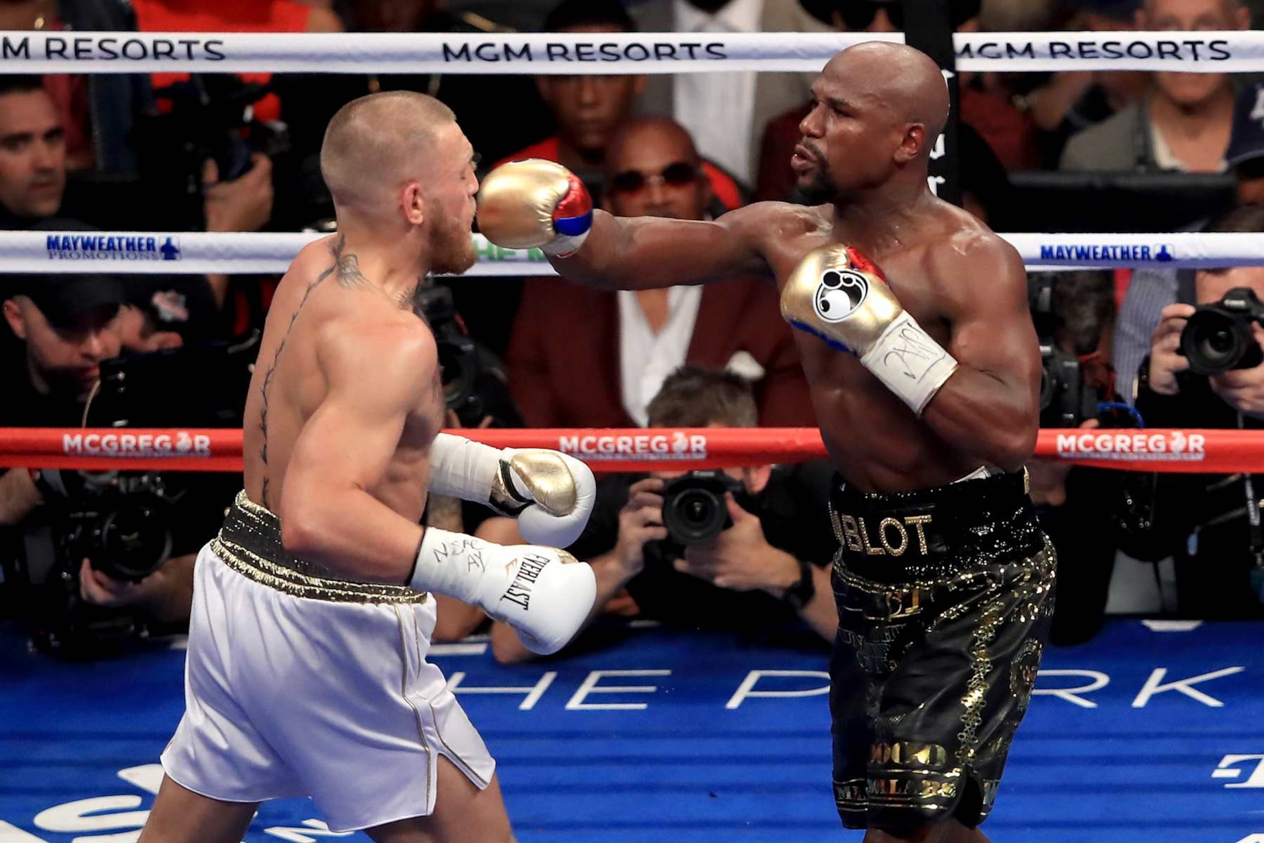 LAS VEGAS, NV - AUGUST 26:  (R-L) Floyd Mayweather Jr. throws a punch at Conor McGregor during their super welterweight boxing match on August 26, 2017 at T-Mobile Arena in Las Vegas, Nevada.  (Photo by Sean M. Haffey/Getty Images)