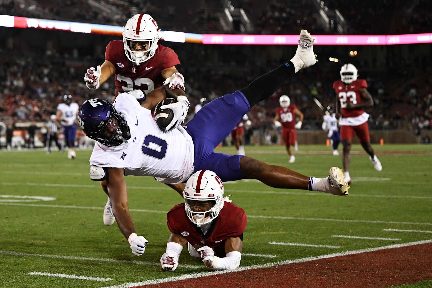 STANFORD, CALIFORNIA - AUGUST 30: DJ Rogers #0 of the TCU Horned Frogs gets tripped up by Collin Wright #6 and Mitch Leigber #32 of the Stanford Cardinal before the play is called back due to a flag in the third quarter at Stanford Stadium on August 30, 2024 in Stanford, California. (Photo by Eakin Howard/Getty Images)
