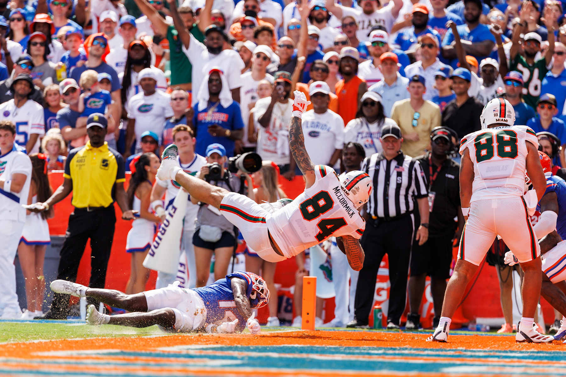 GAINESVILLE, FLORIDA - AUGUST 31: Cam McCormick #84 of the Miami Hurricanes scores a touchdown against Jordan Castell #14 of the Florida Gators during the first half of a game at Ben Hill Griffin Stadium on August 31, 2024 in Gainesville, Florida. (Photo by James Gilbert/Getty Images)