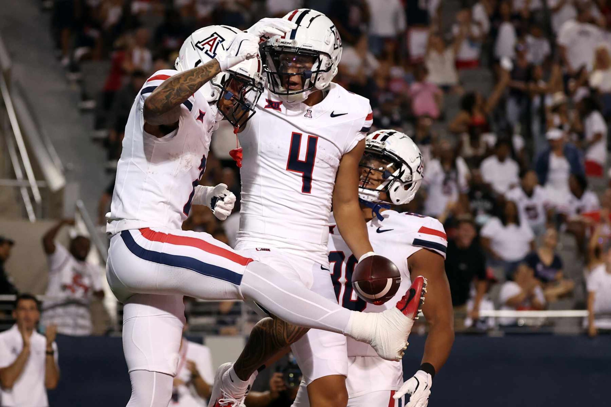 TUCSON, ARIZONA - AUGUST 31: Wide receiver Tetairoa McMillan #4 of the Arizona Wildcats celebrates with wide receiver Jeremiah Patterson #2 after scoring a touchdown during the third quarter against the New Mexico Lobos at Arizona Stadium on August 31, 2024 in Tucson, Arizona.  (Photo by Chris Coduto/Getty Images)