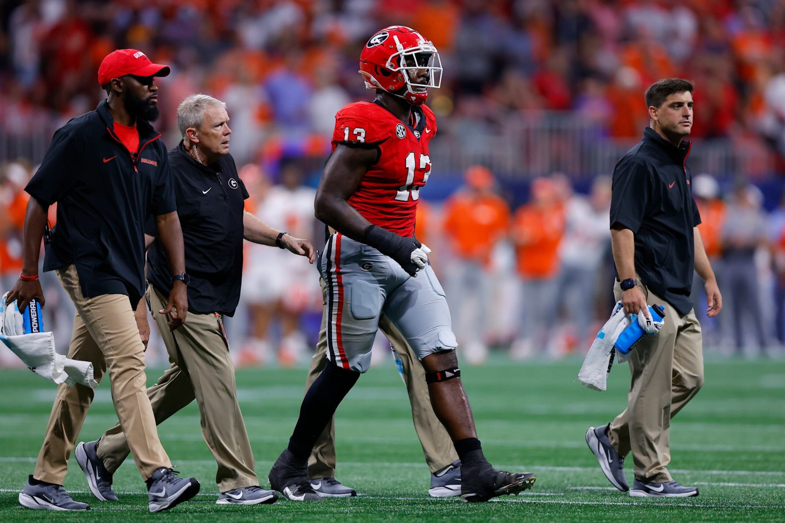 ATHENS, GEORGIA - AUGUST 31: Mykel Williams #13 of the Georgia Bulldogs is helped off the field following an injury during the third quarter against the Clemson Tigers in the Aflac Kickoff Game at Mercedes-Benz Stadium on August 31, 2024 in Atlanta, Georgia.  (Photo by Todd Kirkland/Getty Images)