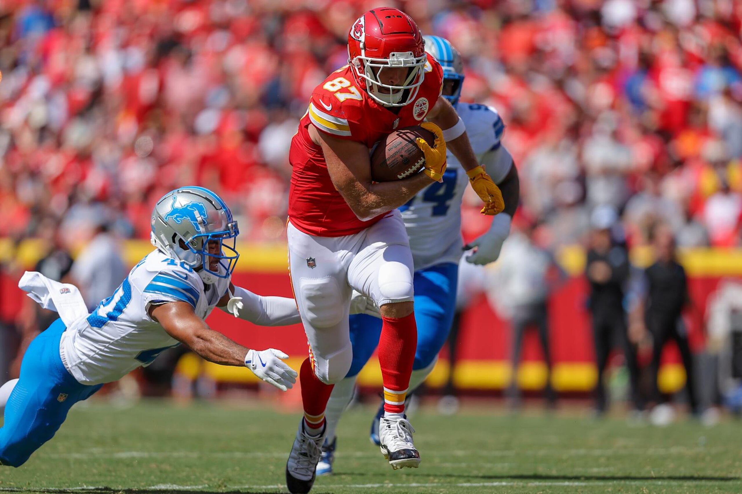 KANSAS CITY, MISSOURI - AUGUST 17: Travis Kelce #87 of the Kansas City Chiefs runs after a first quarter pass catch near Brandon Joseph #40 of the Detroit Lions during preseason game action at GEHA Field at Arrowhead Stadium on August 17, 2024 in Kansas City, Missouri. (Photo by David Eulitt/Getty Images)