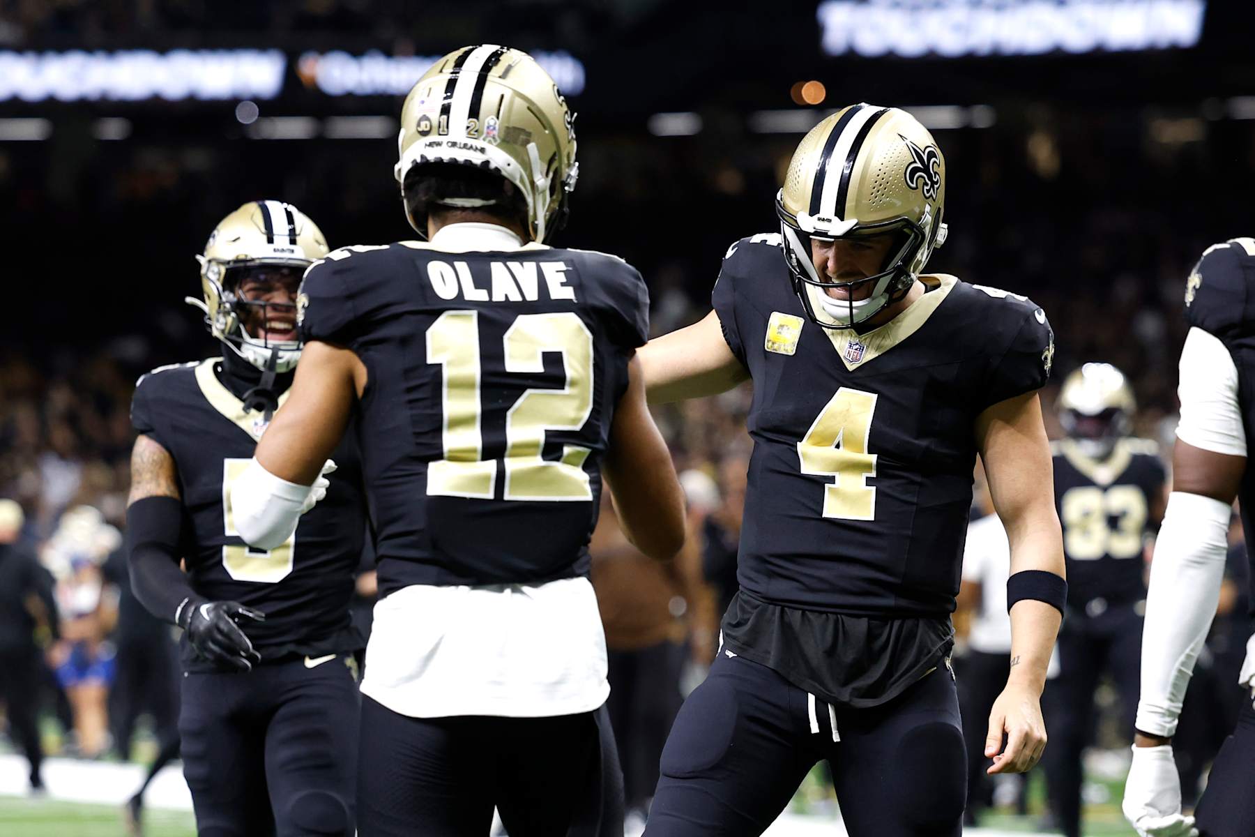 Saints WR Chris Olave (left) and QB Derek Carr (right)