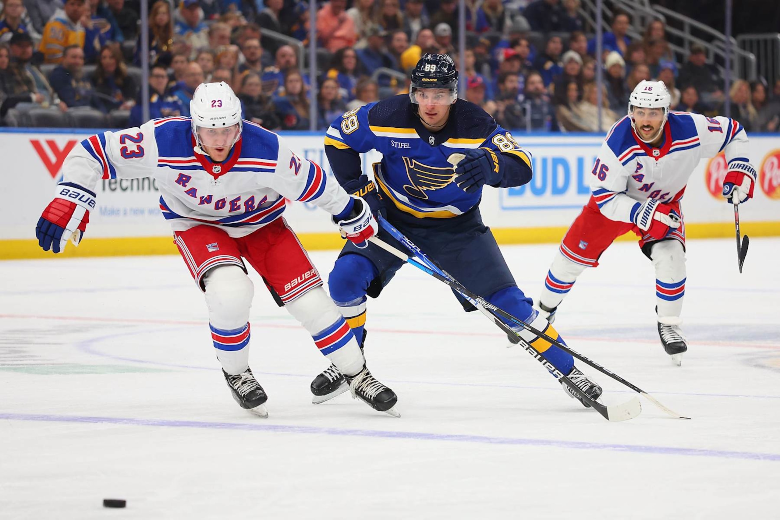 St. Louis Blues winger Pavel Buchnevich (center) races for the puck with New York Rangers defenseman Adam Fox. St. Louis Blues winger Pavel Buchnevich (center) races for the puck with New York Rangers defenseman Adam Fox.
