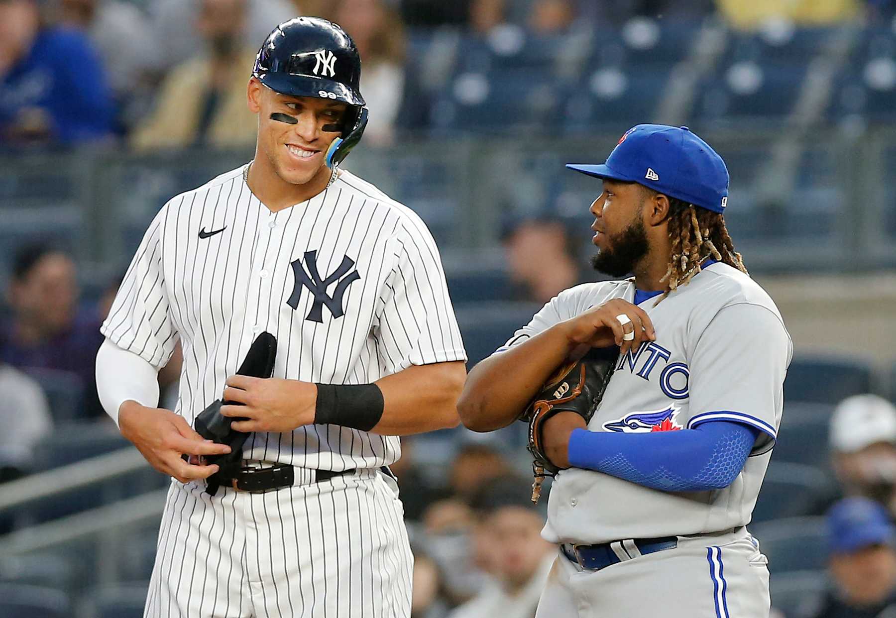 NEW YORK, NEW YORK - APRIL 13:  Aaron Judge #99 of the New York Yankees and Vladimir Guerrero Jr. #27 of the Toronto Blue Jays have a laugh at first base during the first inning at Yankee Stadium on April 13, 2022 in New York City. (Photo by Jim McIsaac/Getty Images)