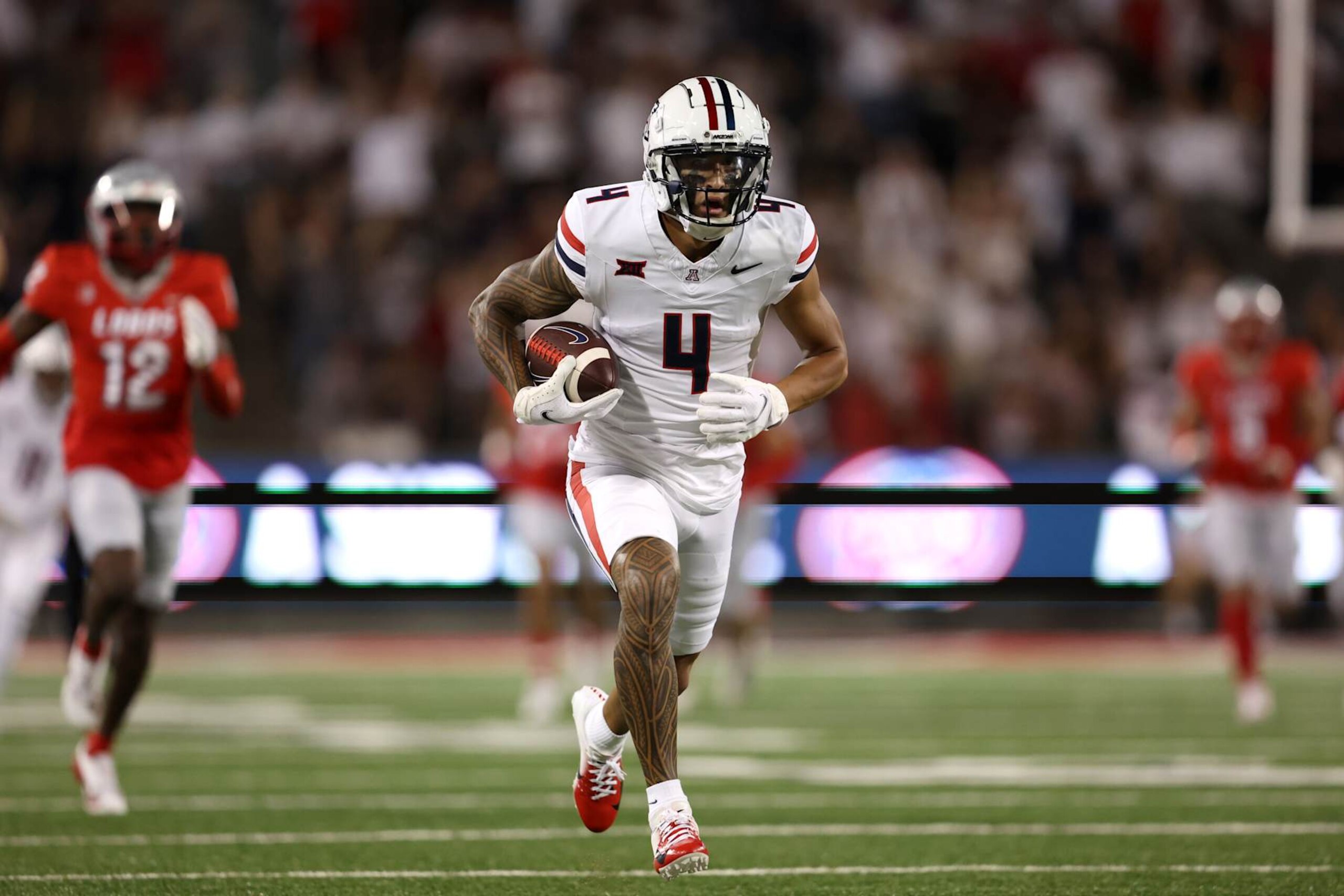 TUCSON, ARIZONA - AUGUST 31: Wide receiver Tetairoa McMillan #4 of the Arizona Wildcats scores a touchdown during the first quarter against the New Mexico Lobos at Arizona Stadium on August 31, 2024 in Tucson, Arizona. (Photo by Chris Coduto/Getty Images) TUCSON, ARIZONA - AUGUST 31: Wide receiver Tetairoa McMillan #4 of the Arizona Wildcats scores a touchdown during the first quarter against the New Mexico Lobos at Arizona Stadium on August 31, 2024 in Tucson, Arizona. (Photo by Chris Coduto/Getty Images)