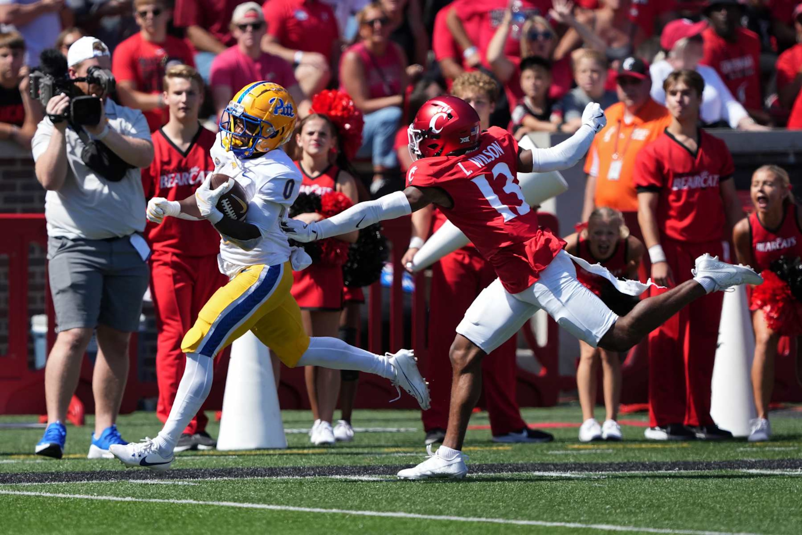 CINCINNATI, OHIO - SEPTEMBER 07: Desmond Reid #0 of the Pittsburgh Panthers runs with the ball while being chased by Logan Wilson #13 of the Cincinnati Bearcats in the fourth quarter at Nippert Stadium on September 07, 2024 in Cincinnati, Ohio. (Photo by Dylan Buell/Getty Images) CINCINNATI, OHIO - SEPTEMBER 07: Desmond Reid #0 of the Pittsburgh Panthers runs with the ball while being chased by Logan Wilson #13 of the Cincinnati Bearcats in the fourth quarter at Nippert Stadium on September 07, 2024 in Cincinnati, Ohio. (Photo by Dylan Buell/Getty Images)