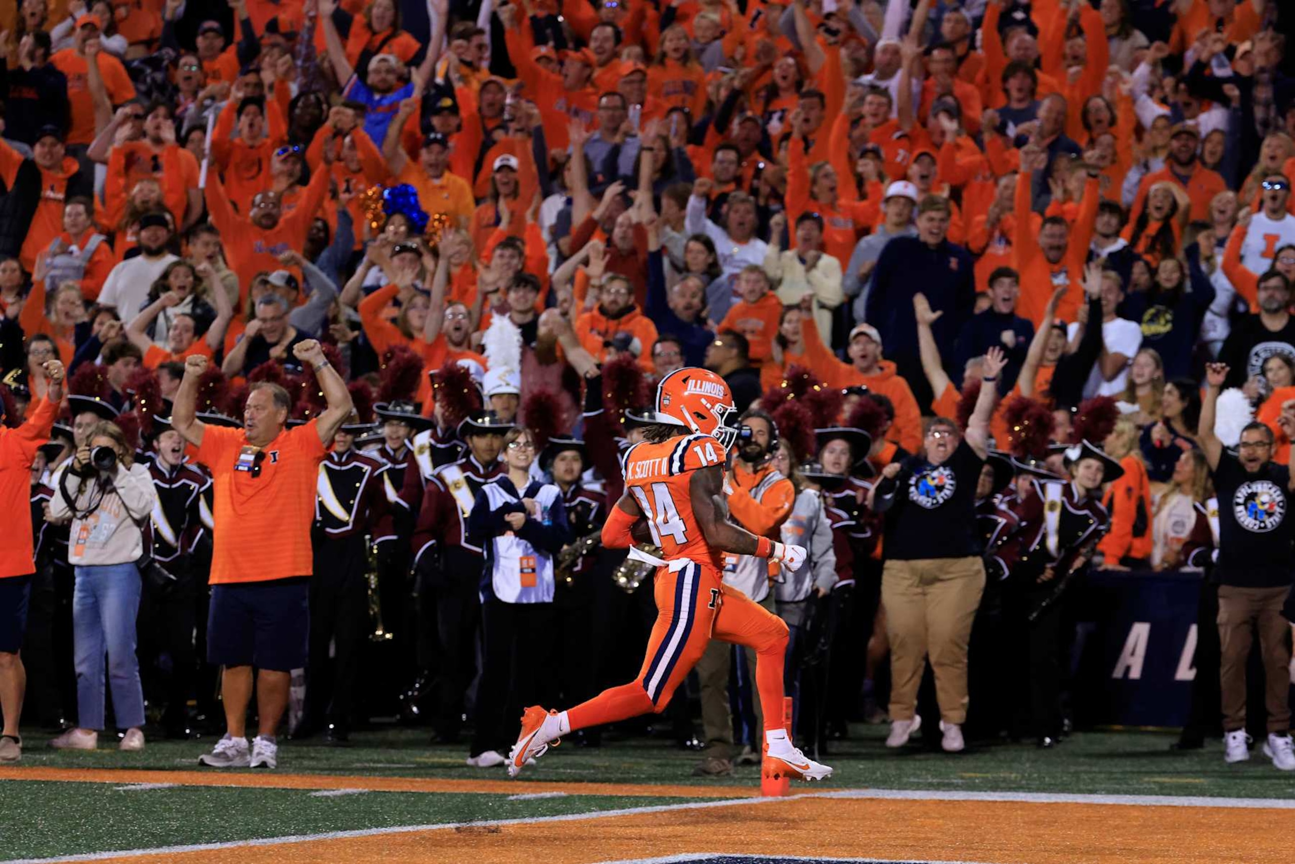 CHAMPAIGN, ILLINOIS - SEPTEMBER 07: Xavier Scott #14 of the Illinois Fighting Illini scores a touchdown after intercepting a pass during the second quarter against the Kansas Jayhawks at Memorial Stadium on September 07, 2024 in Champaign, Illinois. (Photo by Justin Casterline/Getty Images)