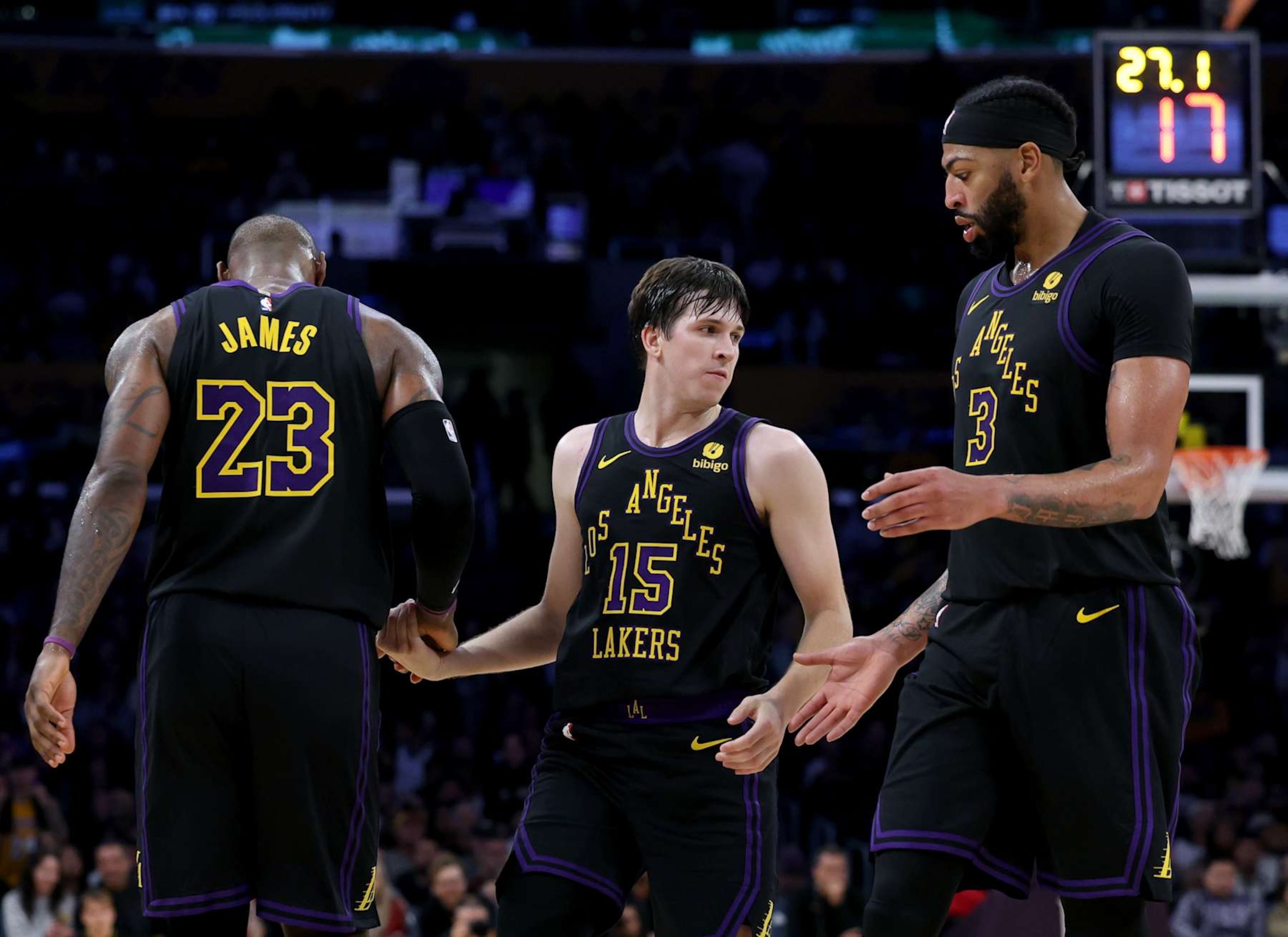 LOS ANGELES, CALIFORNIA - DECEMBER 18: Austin Reaves #15 of the Los Angeles Lakers is helped up by LeBron James #23 and Anthony Davis #3 during a 114-109 loss to the New York Knicks at Crypto.com Arena on December 18, 2023 in Los Angeles, California. NOTE TO USER: User expressly acknowledges and agrees that, by downloading and or using this photograph, User is consenting to the terms and conditions of the Getty Images License Agreement. (Photo by Harry How/Getty Images)