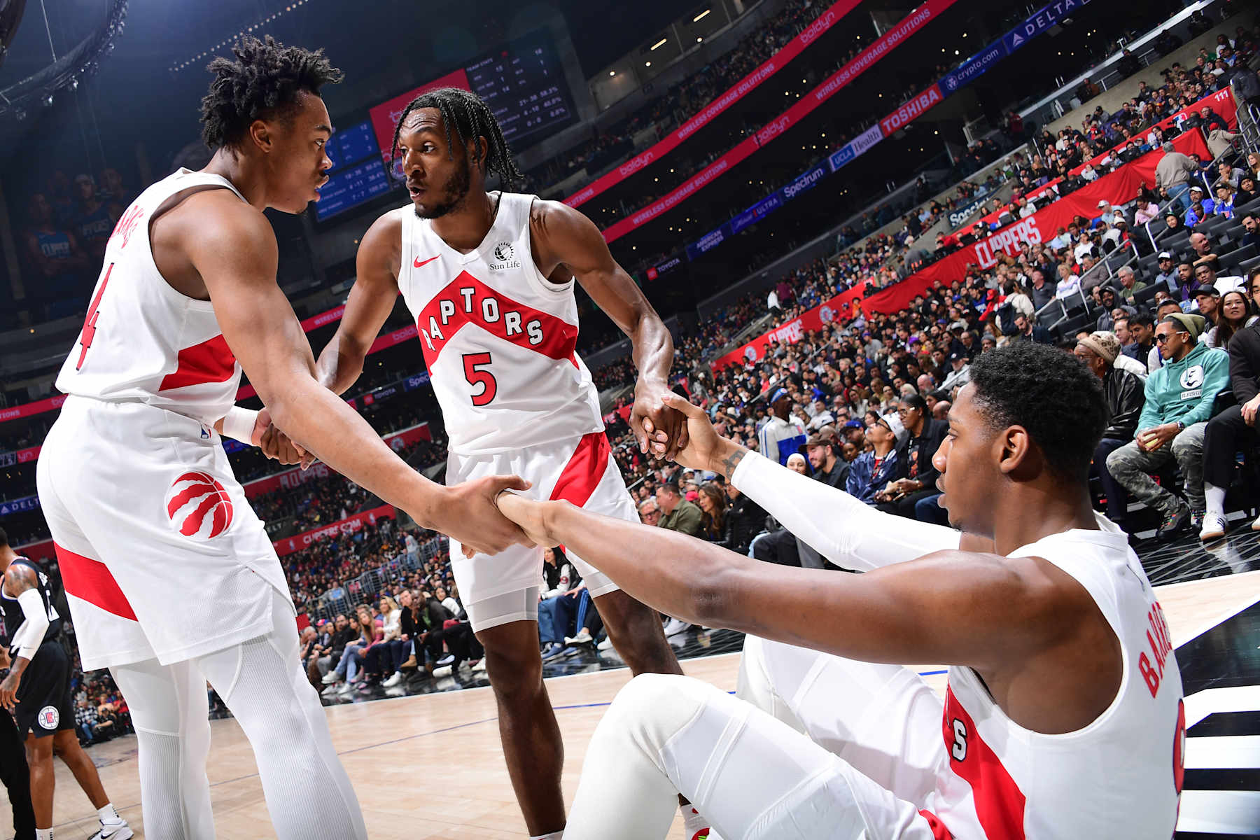 LOS ANGELES, CA - JANUARY 10: RJ Barrett #9 is helped up by his teammates Scottie Barnes #4 and Immanuel Quickley #5 of the Toronto Raptors during the game against the LA Clippers on January 10, 2024 at Crypto.Com Arena in Los Angeles, California. NOTE TO USER: User expressly acknowledges and agrees that, by downloading and/or using this Photograph, user is consenting to the terms and conditions of the Getty Images License Agreement. Mandatory Copyright Notice: Copyright 2024 NBAE (Photo by Adam Pantozzi/NBAE via Getty Images)