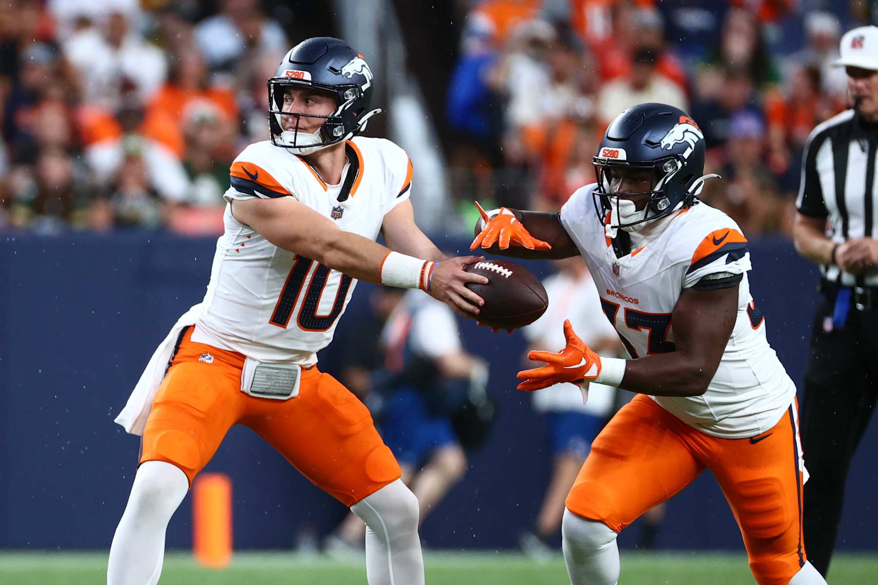 DENVER, COLORADO - AUGUST 18: Bo Nix #10 hands the ball off to Javonte Williams #33 of the Denver Broncos in the first half during the preseason game against the Green Bay Packers at Empower Field At Mile High on August 18, 2024 in Denver, Colorado. (Photo by Tyler Schank/Getty Images)