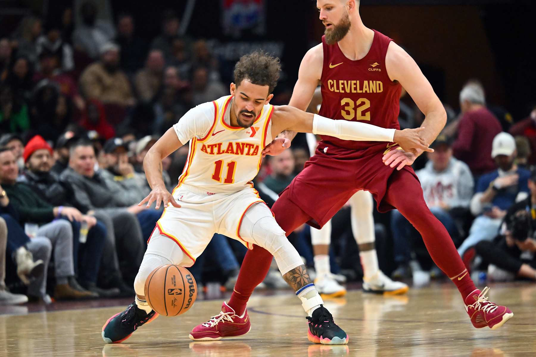 CLEVELAND, OHIO - DECEMBER 16: Trae Young #11 of the Atlanta Hawks tries to run a play while under pressure from Dean Wade #32 of the Cleveland Cavaliers during the fourth quarter at Rocket Mortgage Fieldhouse on December 16, 2023 in Cleveland, Ohio. The Cavaliers defeated the Hawks 127-119. NOTE TO USER: User expressly acknowledges and agrees that, by downloading and or using this photograph, User is consenting to the terms and conditions of the Getty Images License Agreement. (Photo by Jason Miller/Getty Images)