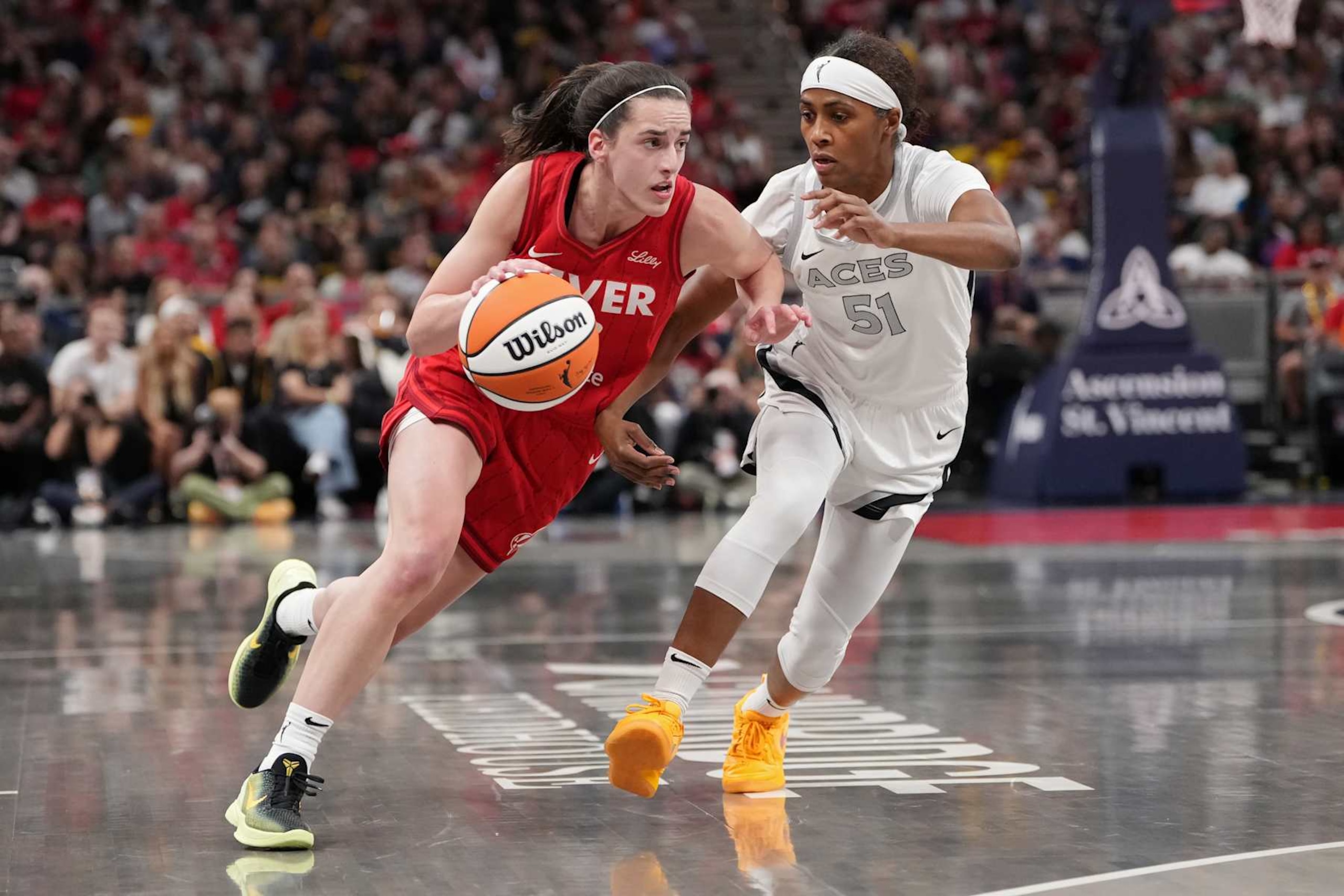 INDIANAPOLIS, INDIANA - SEPTEMBER 11: Caitlin Clark #22 of the Indiana Fever dribbles the ball while being guarded by Sydney Colson #51 of the Las Vegas Aces in the first quarter at Gainbridge Fieldhouse on September 11, 2024 in Indianapolis, Indiana. NOTE TO USER: User expressly acknowledges and agrees that, by downloading and or using this photograph, User is consenting to the terms and conditions of the Getty Images License Agreement. (Photo by Dylan Buell/Getty Images)