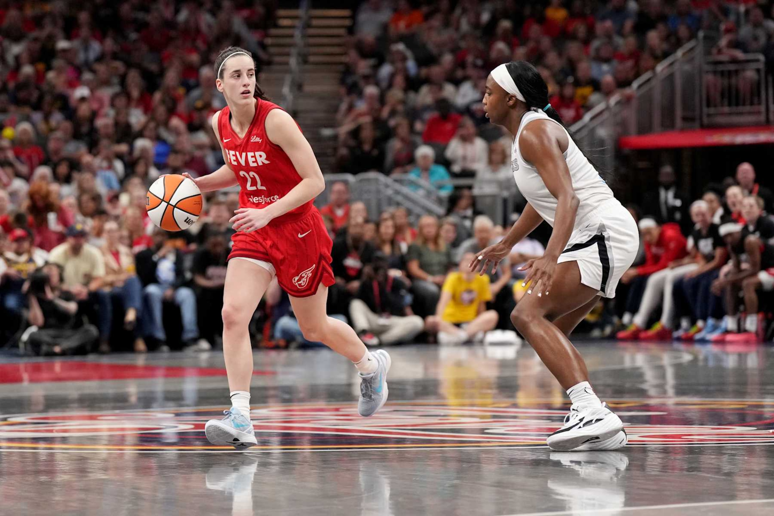 INDIANAPOLIS, INDIANA - SEPTEMBER 13: Caitlin Clark #22 of the Indiana Fever drives the ball up court against Jackie Young #0 of the Las Vegas Aces during the first half of a game at Gainbridge Fieldhouse on September 13, 2024 in Indianapolis, Indiana. NOTE TO USER: User expressly acknowledges and agrees that, by downloading and or using this photograph, User is consenting to the terms and conditions of the Getty Images License Agreement. (Photo by Emilee Chinn/Getty Images)