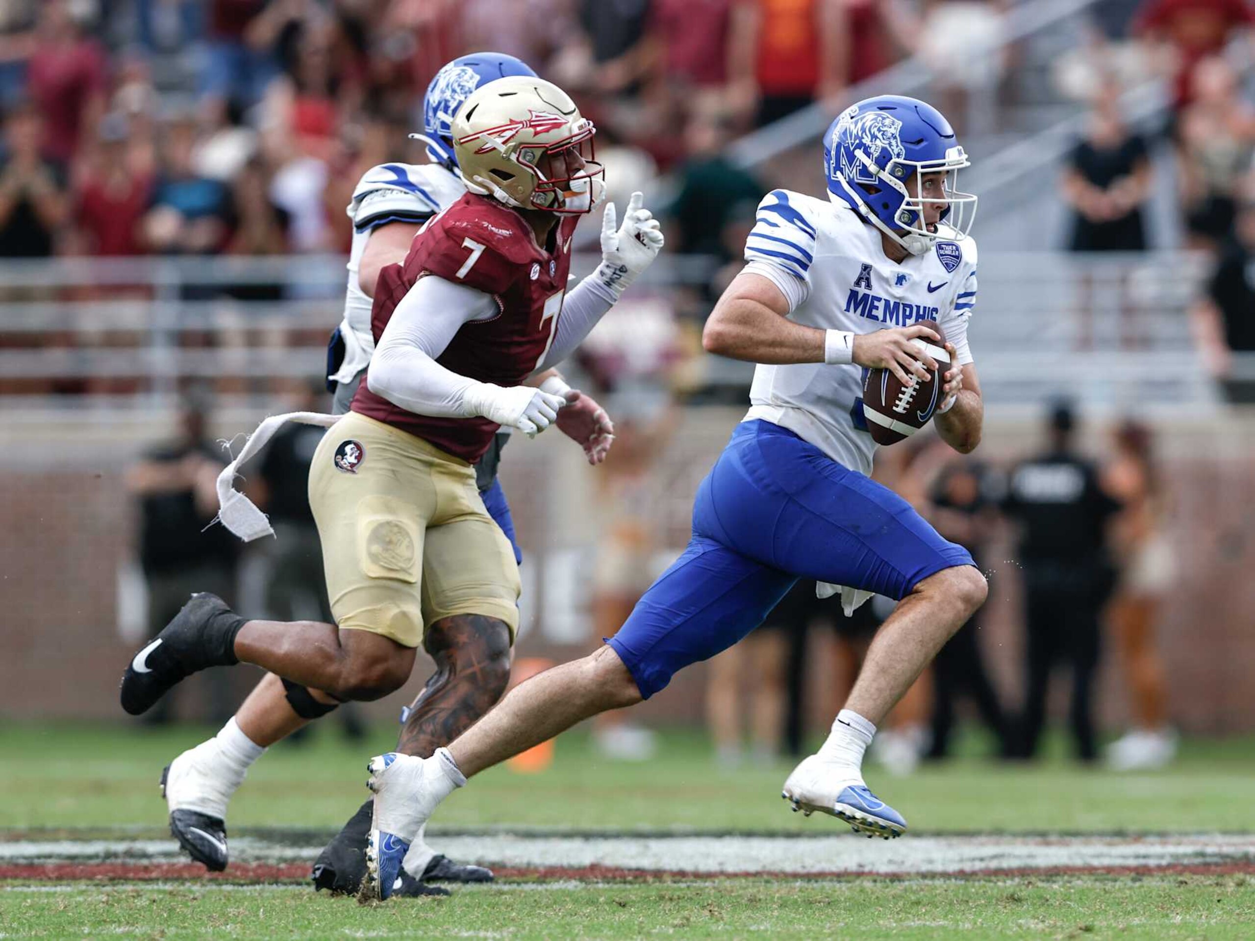 TALLAHASSEE, FL - SEPTEMBER 14: Quarterback Seth Henigan #9 of the Memphis Tigers is forced out the pocket by Defensive End Marvin Jones Jr. #7 of the Florida State Seminoles during the game at Doak Campbell Stadium on Bobby Bowden Field on September 14, 2024 in Tallahassee, Florida. The Tigers defeated the Seminoles 20 to 12. (Photo by Don Juan Moore/Getty Images)